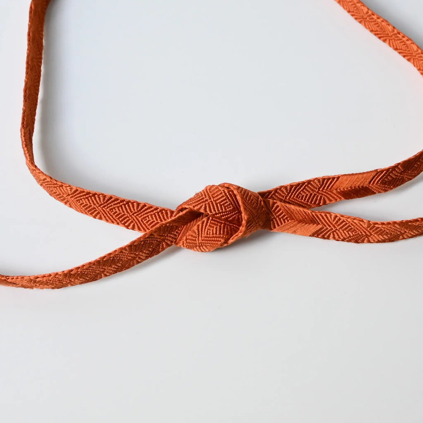 Recycled silk obijime cord in a beautiful burnt orange, intricately braided.