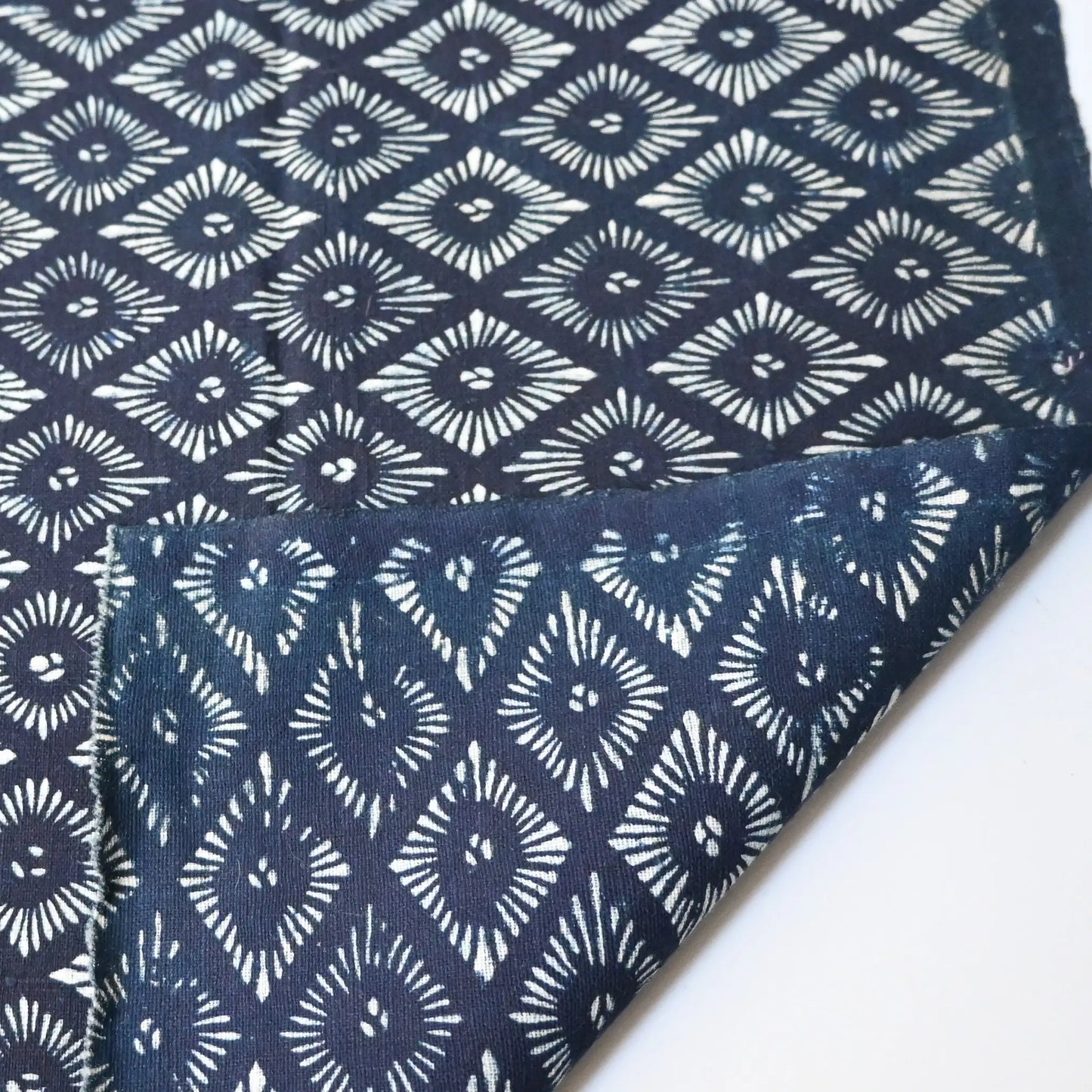Detailed view of antique indigo katazome dyed cotton with stylised chrysanthemum motif from the early 20th century.
