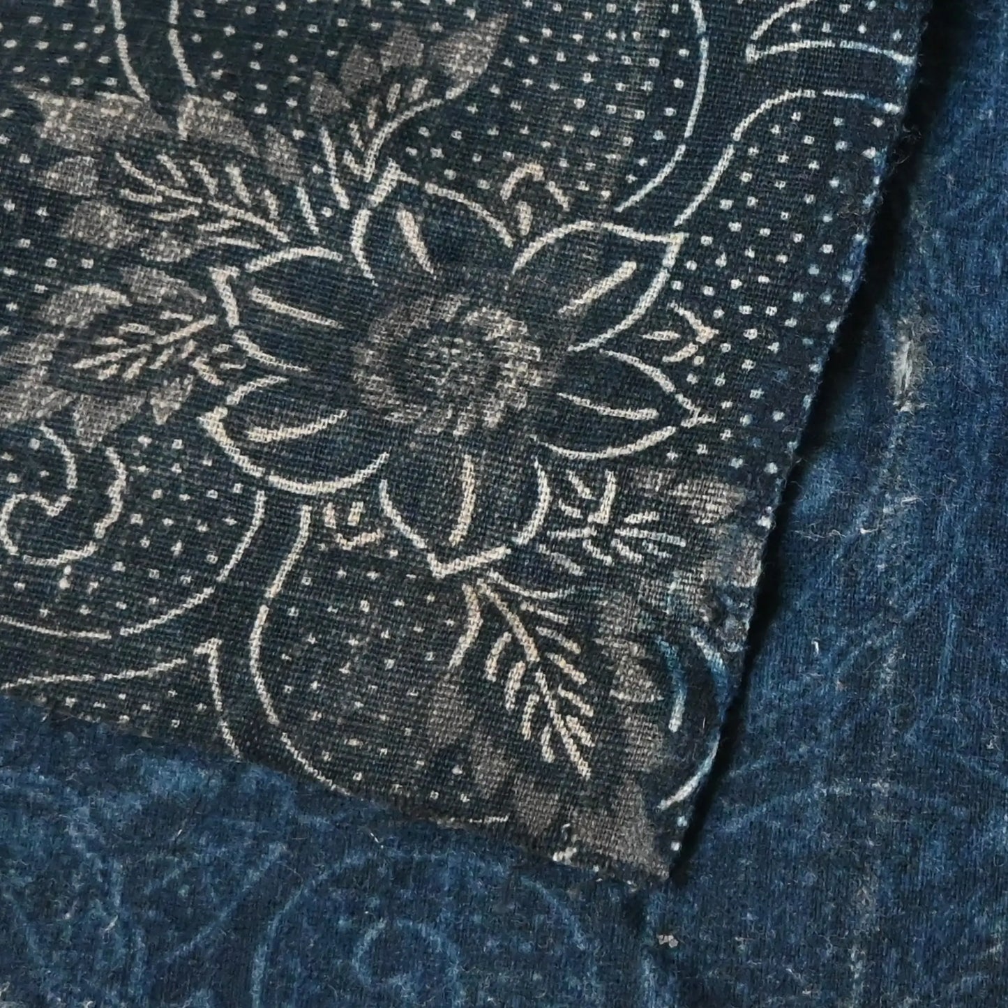 Detailed view of antique Japanese indigo Katazome dyed cotton with a floral arabesque motif in indigo and grey.