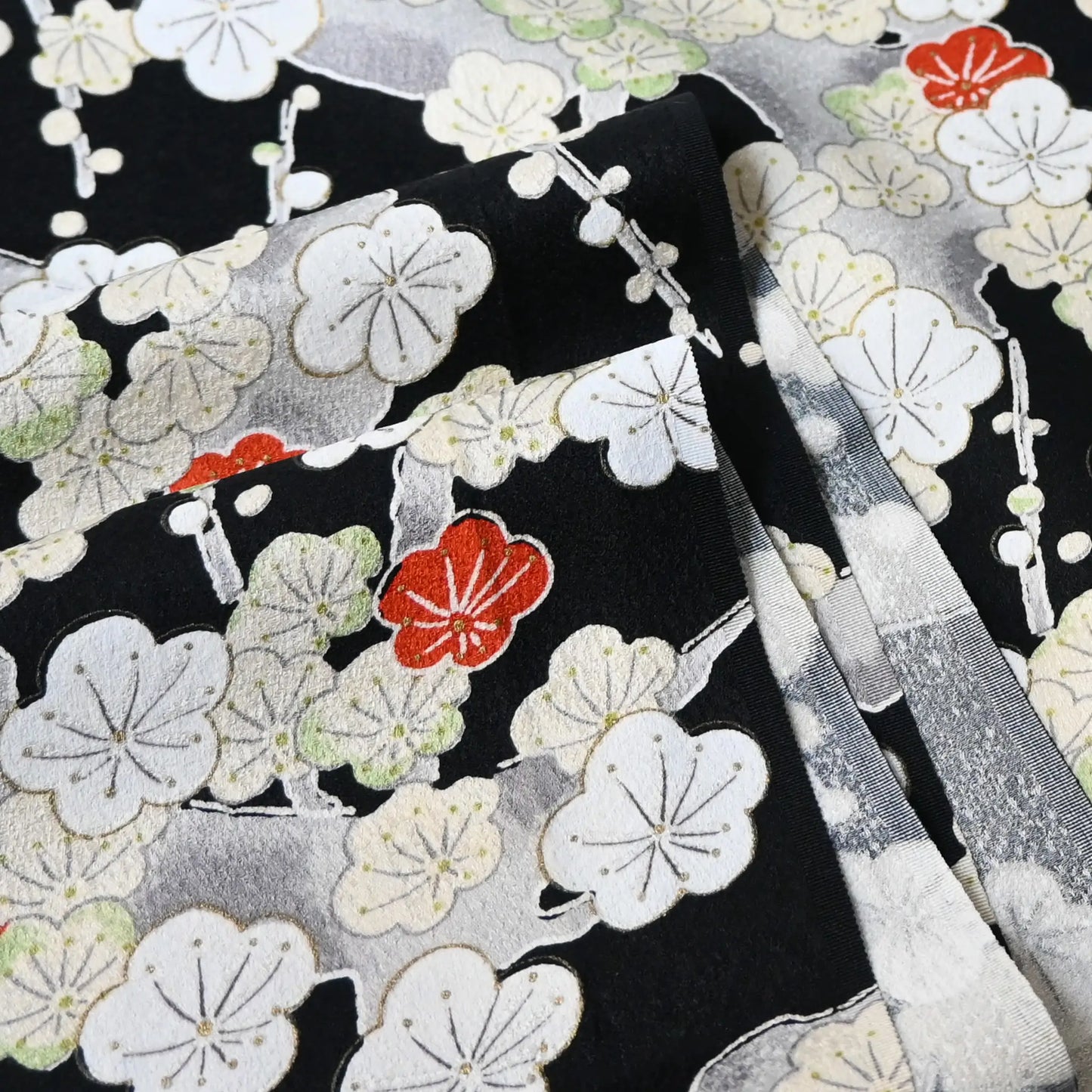 Detailed view of vintage women's silk kimono fabric piece in black with plum blossom design.