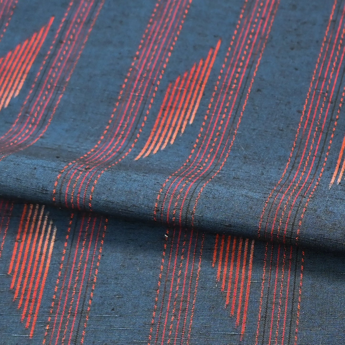 Detailed view of vintage Japanese blue tsumugi silk kimono fabric piece with red line pattern.