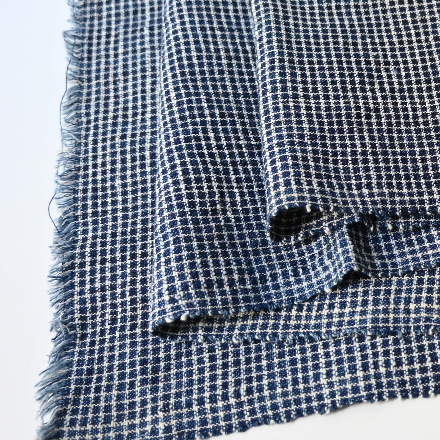 Close-up view of vintage Chinese hand loomed indigo check cotton piece.