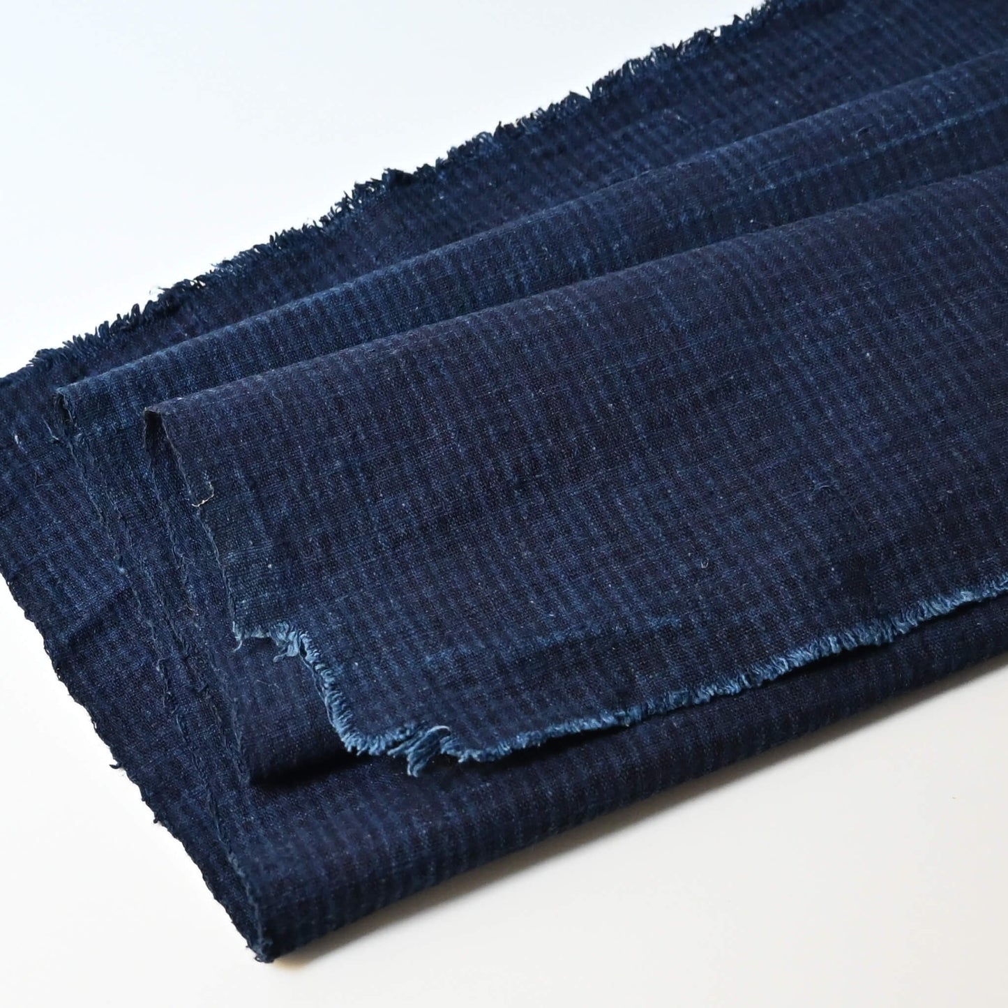Close-up vintage Chinese indigo check cotton piece with natural texture.