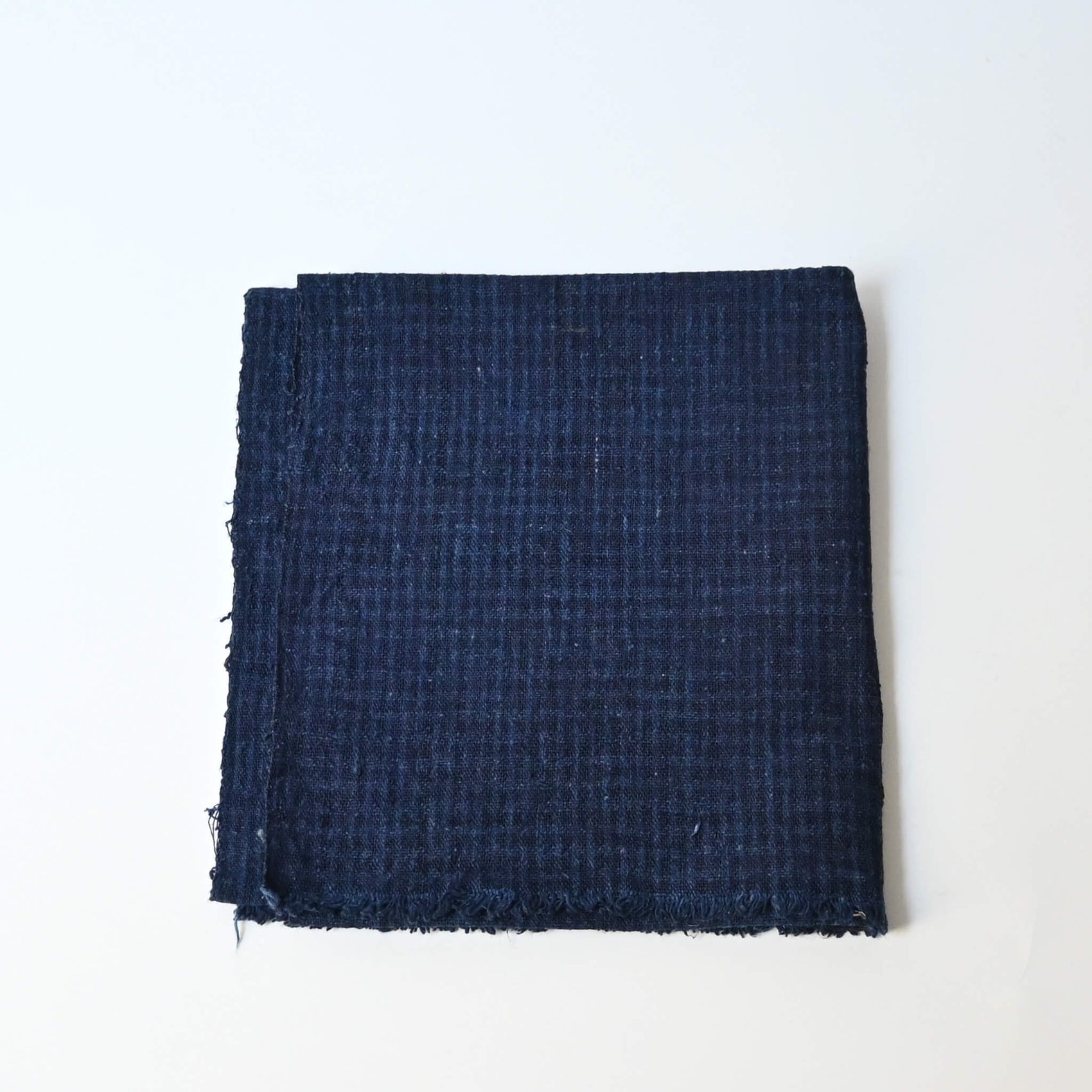 Vintage Chinese indigo check cotton piece with natural texture.