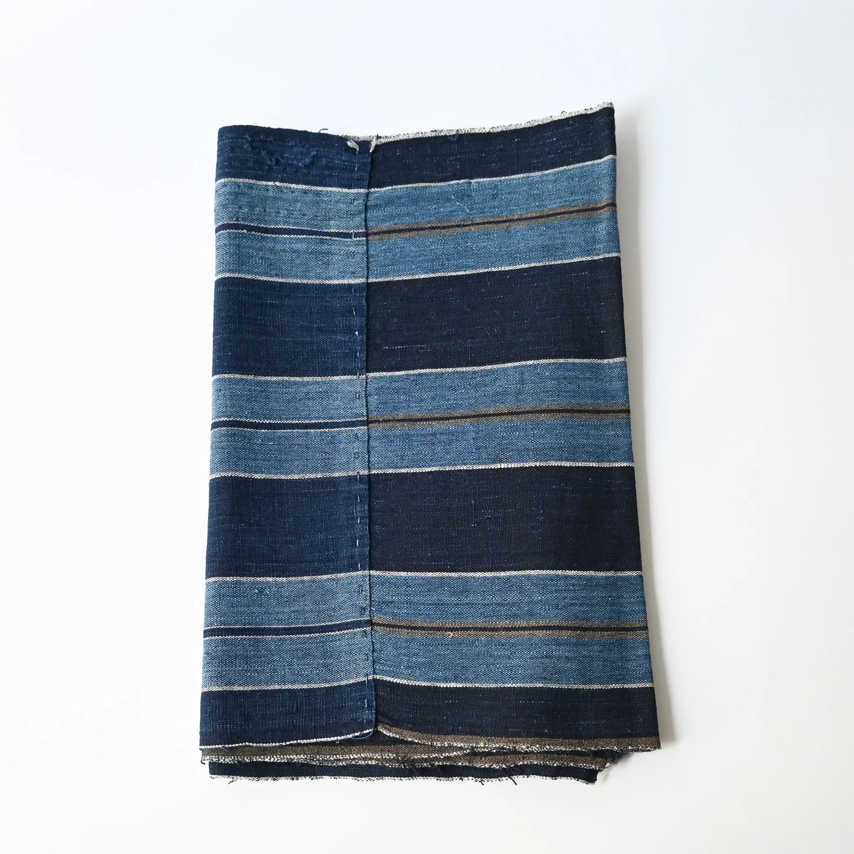 Vintage indigo stripe cotton from a futon cover, two different stripe patterns joined together with mended patches.