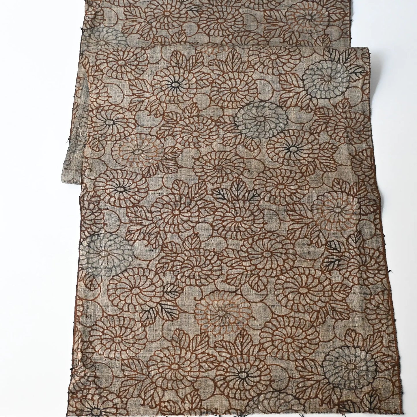 Full view of vintage tsumugi silk kimono fabric in earthy greige colour with brown chrysanthemum motif.
