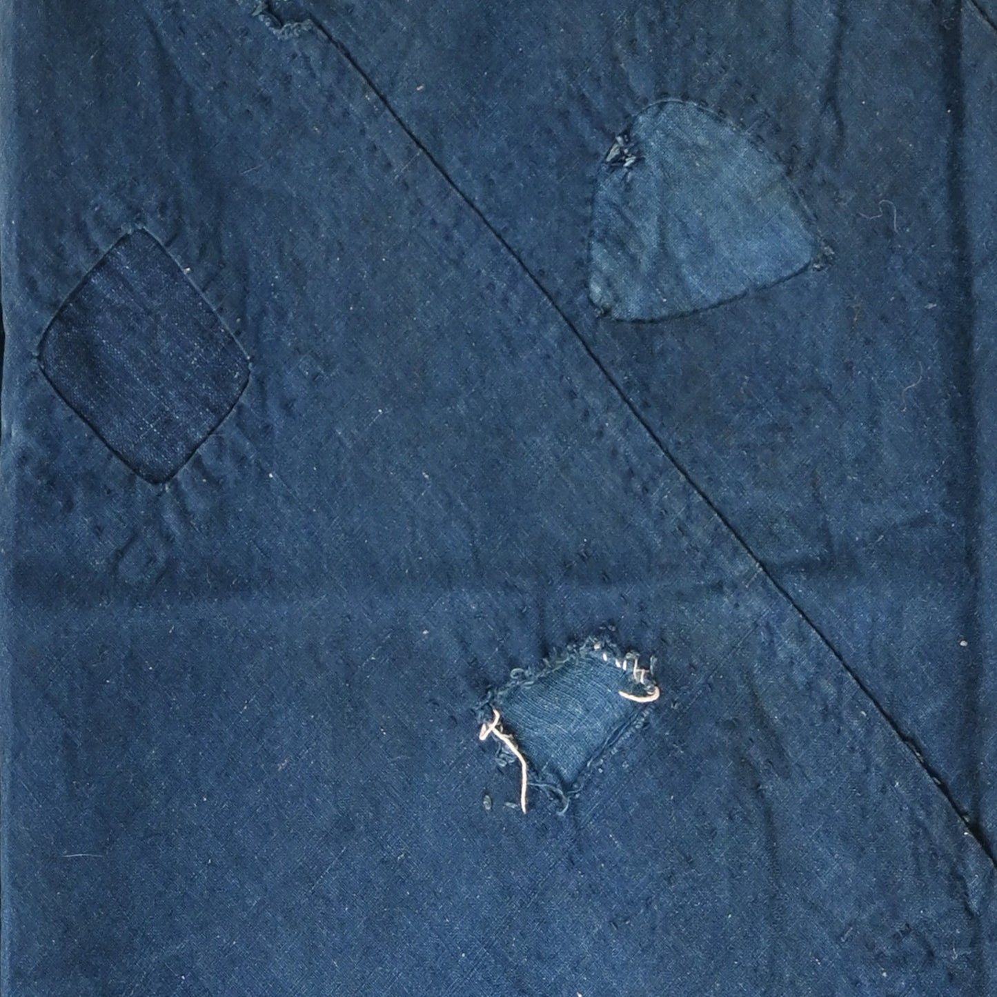 Detailed view of rare vintage indigo cotton tube cloth with mends.