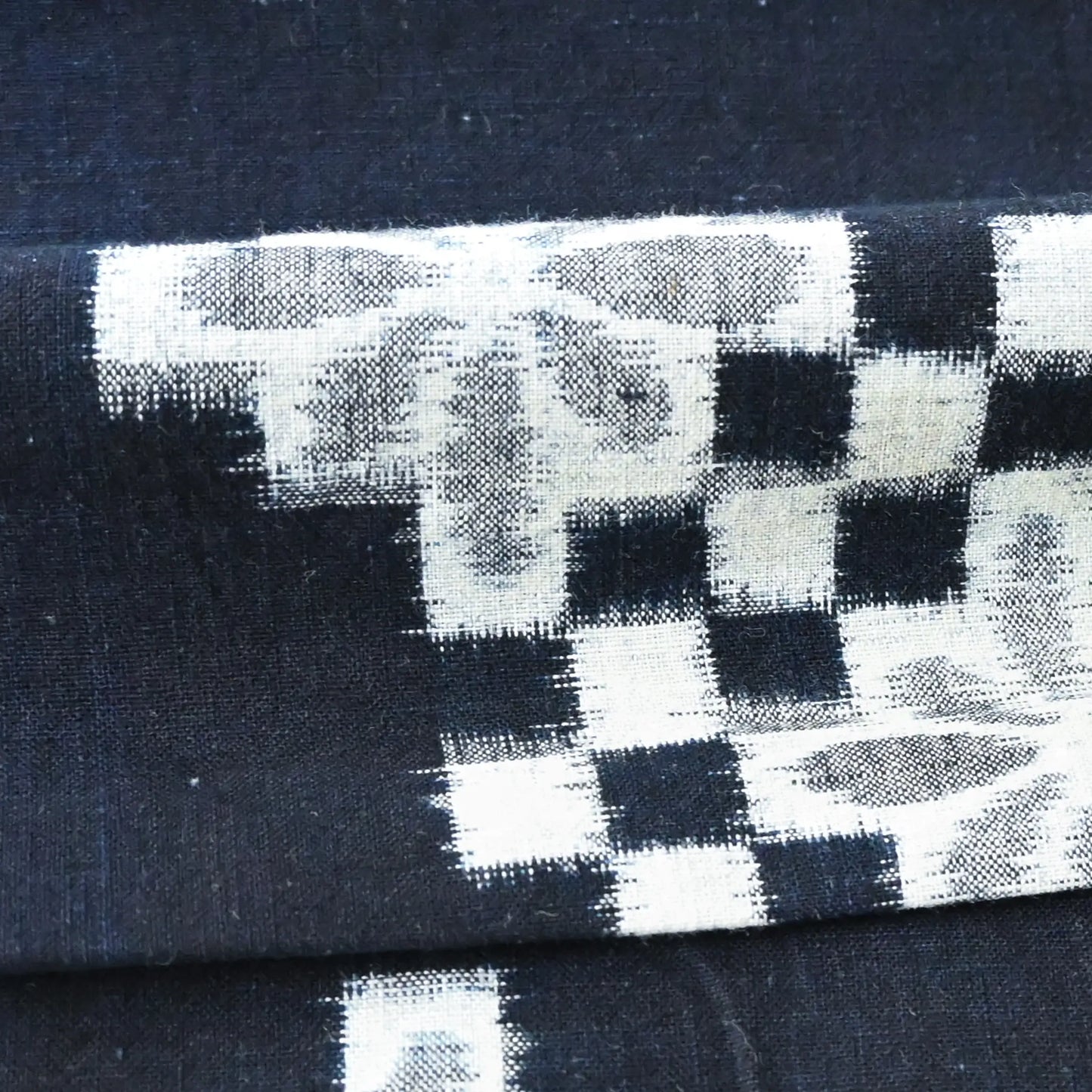 Detailed view of vintage indigo Egasuri cotton piece with square and chrysanthemum motif.