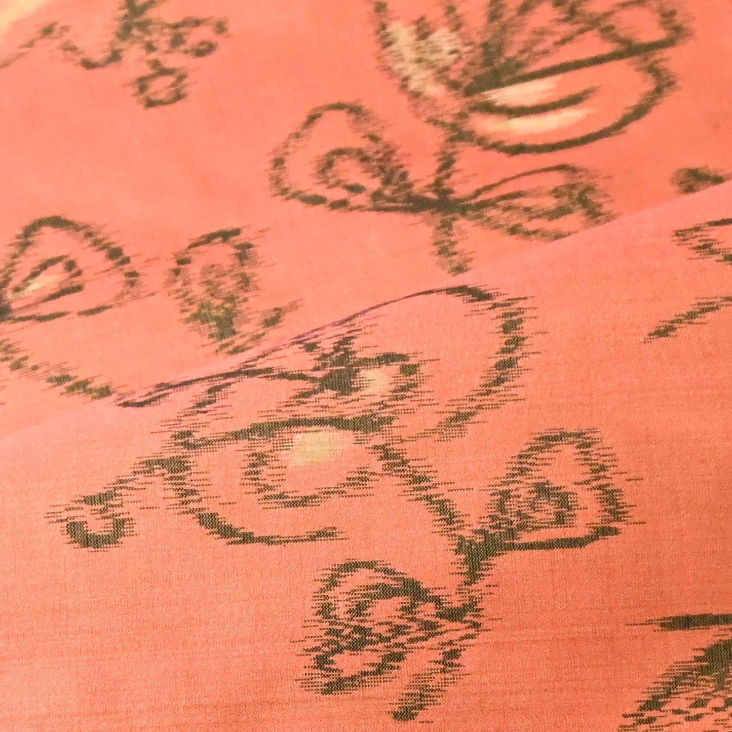 Detailed view of vintage Japanese coral pink Mensen kimono silk fabric with abstract floral pattern from the mid-20th century.