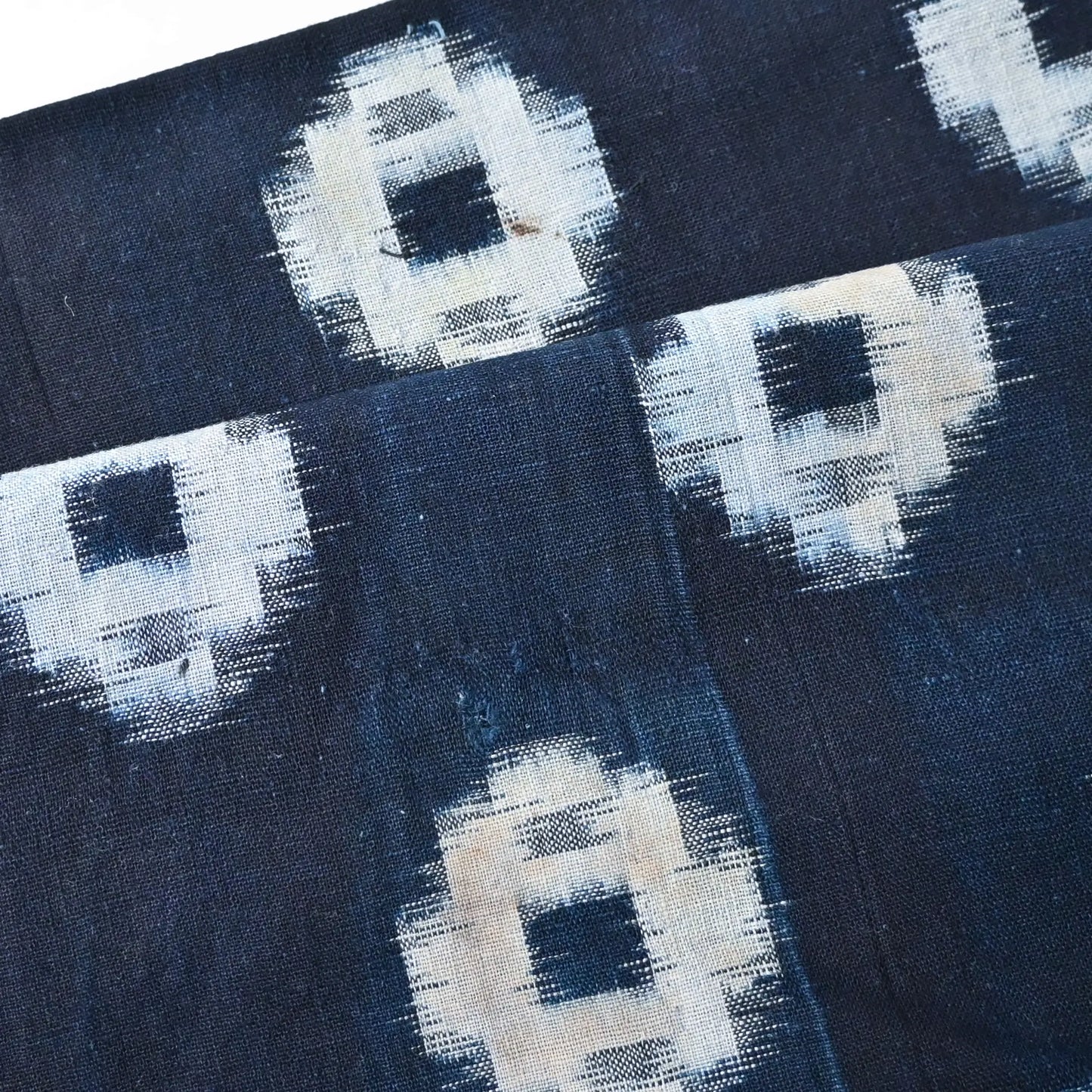 Detailed view of vintage Japanese indigo kasuri cotton piece with some stains.