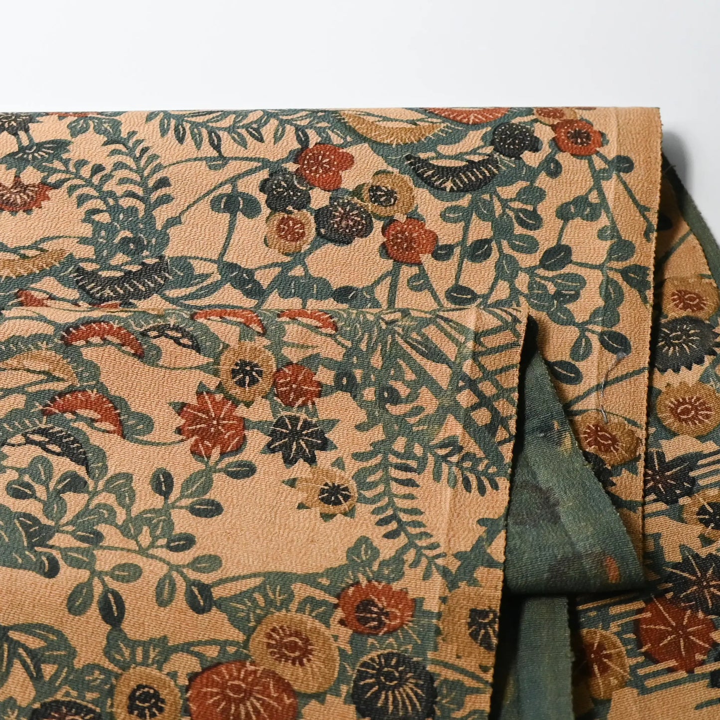 Detailed view of vintage Japanese katazome silk crepe kimono fabric with various seasonal flowers in earthy tones.