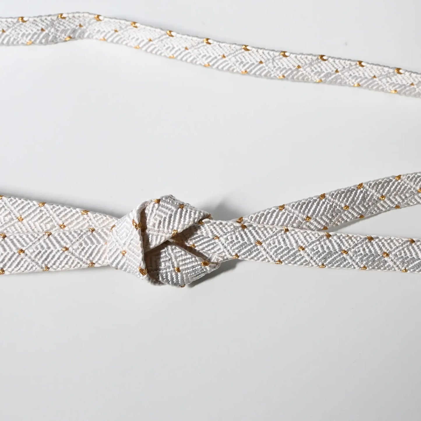 Vintage Japanese Kumihimo braided silk Obijime in white with gold dot design tied in a knot.