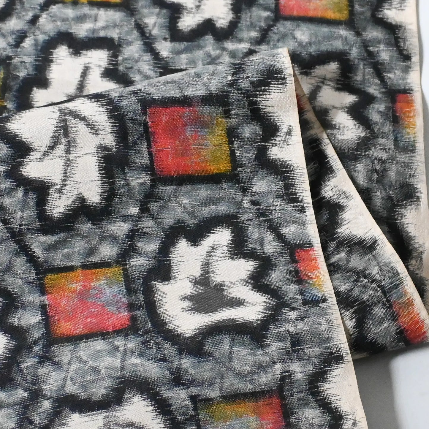 Detailed view of vintage Japanese Meisen silk kimono fabric piece with a leaf motif in grey and pink from the mid-20th century.