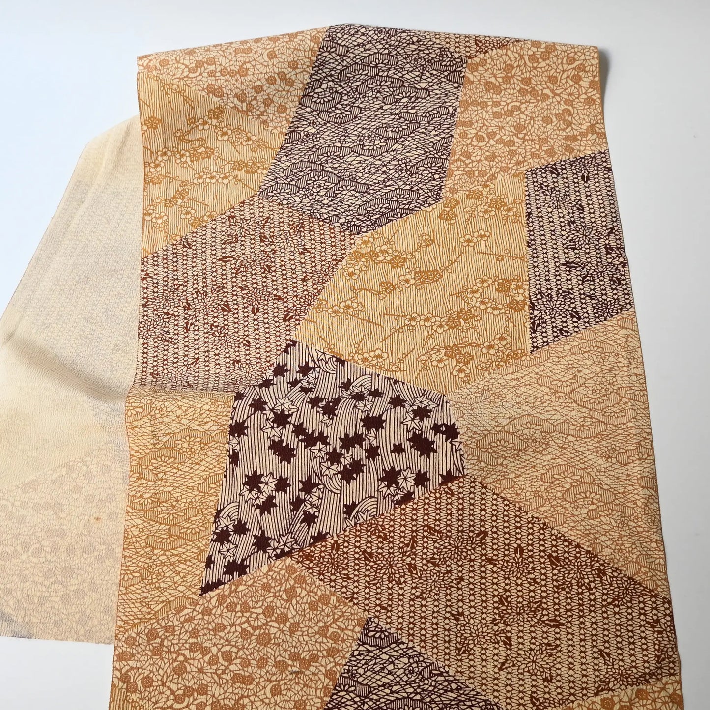 Full view of vintage Japanese silk crepe kimono fabric with traditional stencil-dyed pattern in a warm colour palette.
