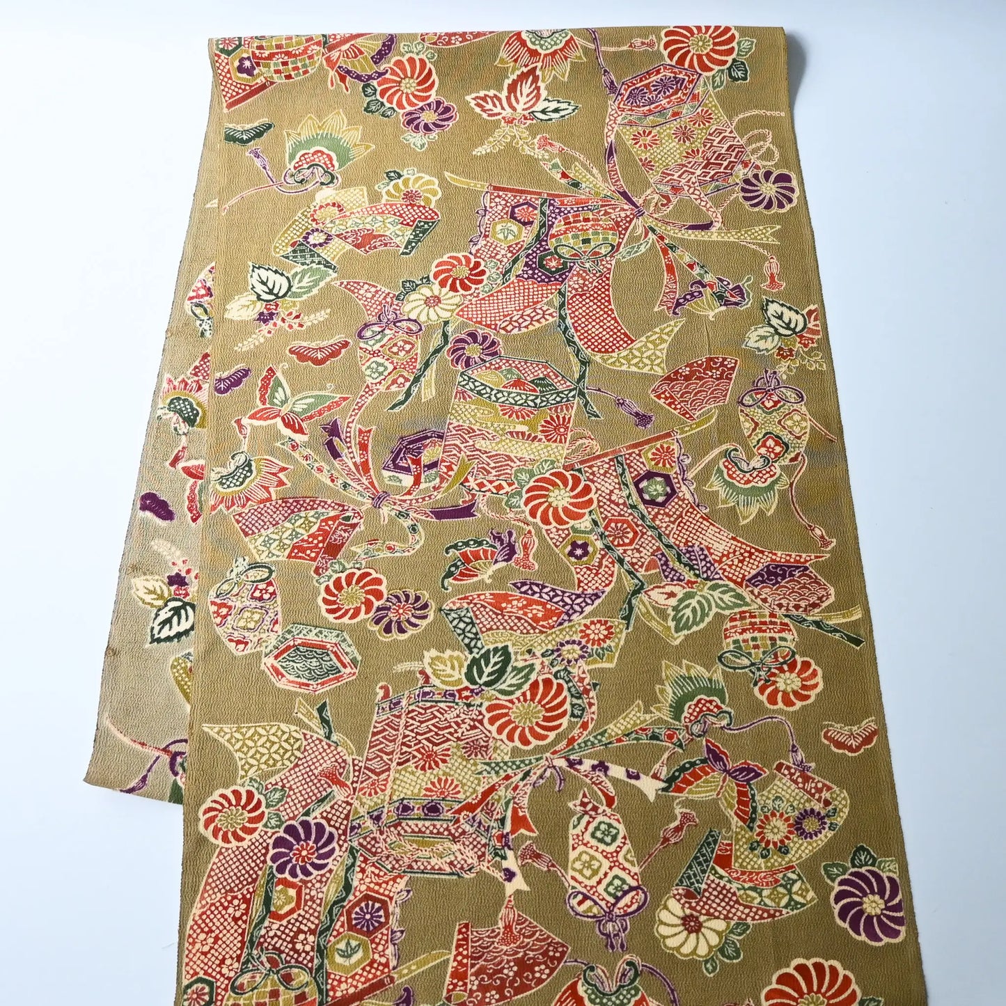 Full view of vintage olive green Chirimen silk crepe with auspicious motifs.