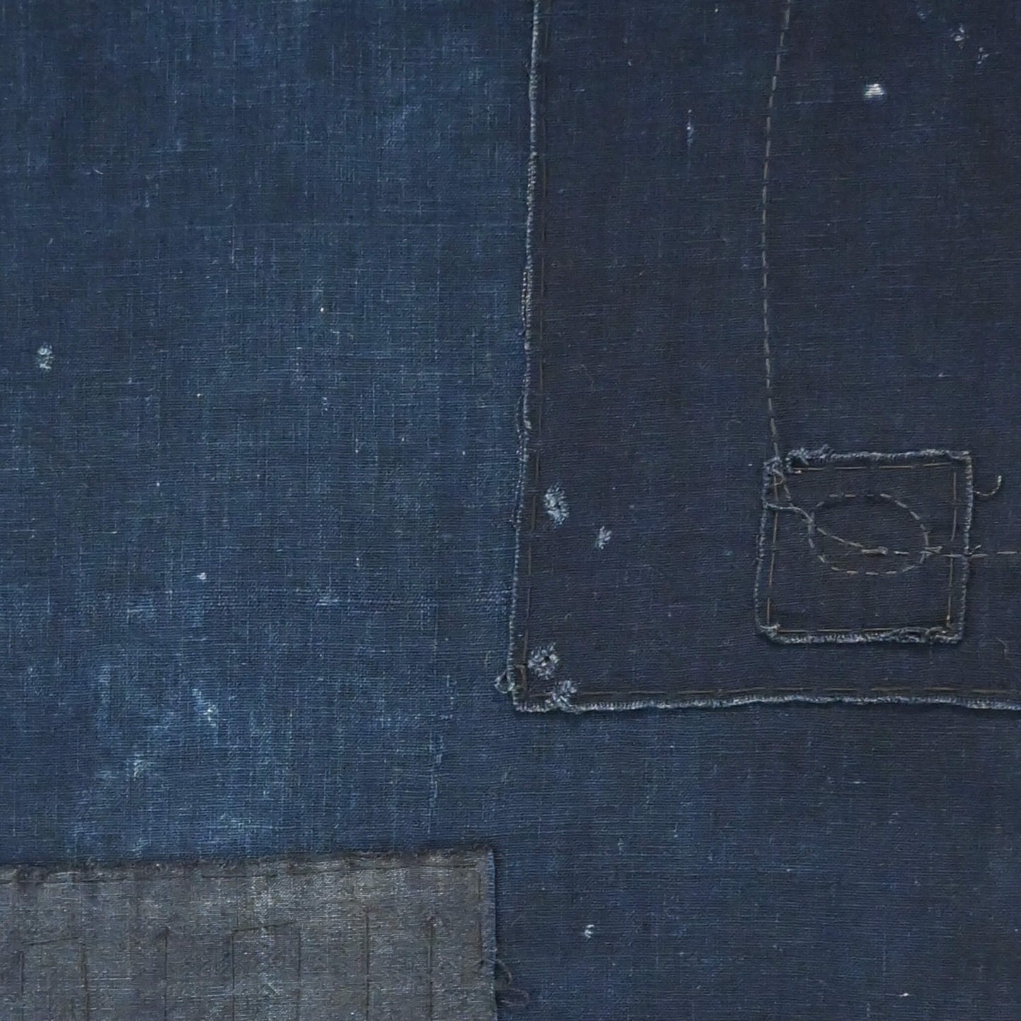 Detailed view of vintage Japanese plain deep indigo cotton futon cover panel with patches.
