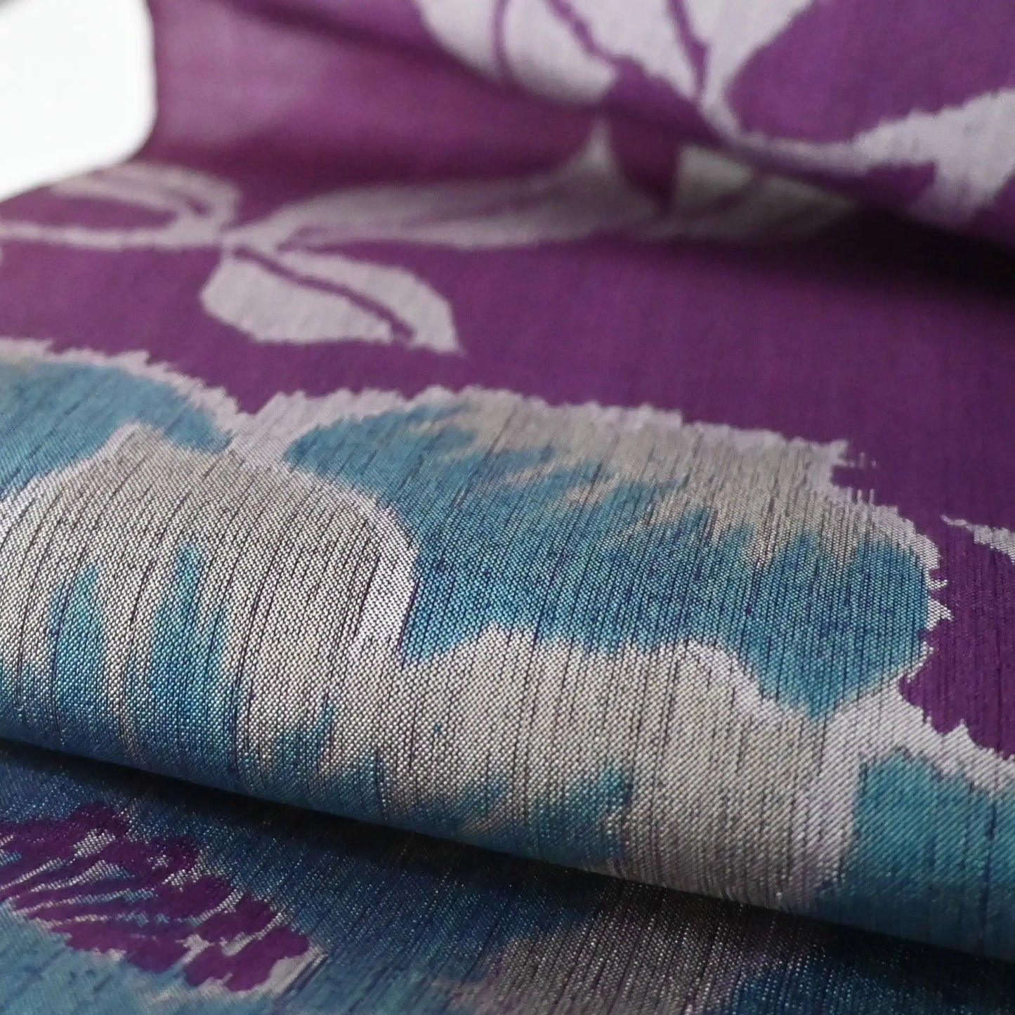 Close-up view of vintage Japanese purple Meisen silk kimono fabric with turquoise peony motif.