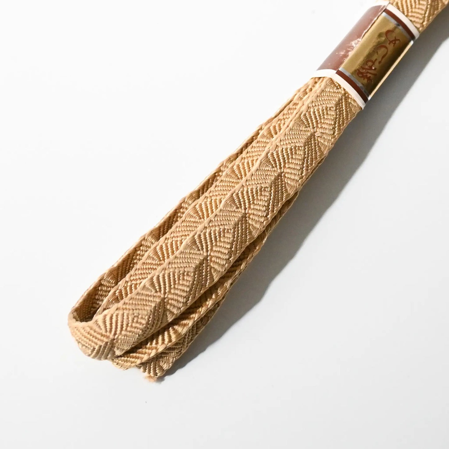 Detailed shot of vintage Japanese Kumihimo braided silk Obijime in soft beige.