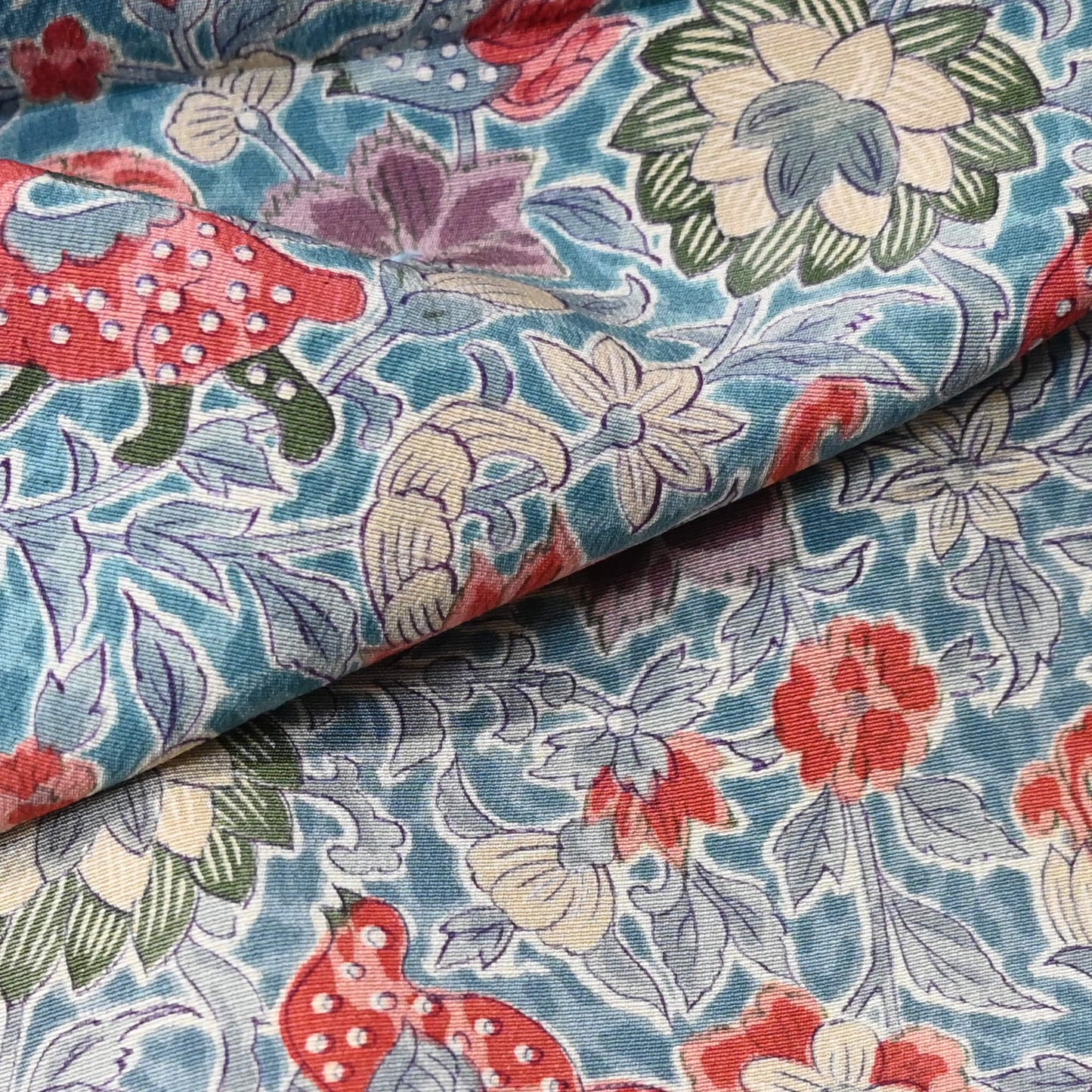 Close-up view of vintage silk crepe kimono fabric piece with Sarasa floral and bird patten in soft blue.