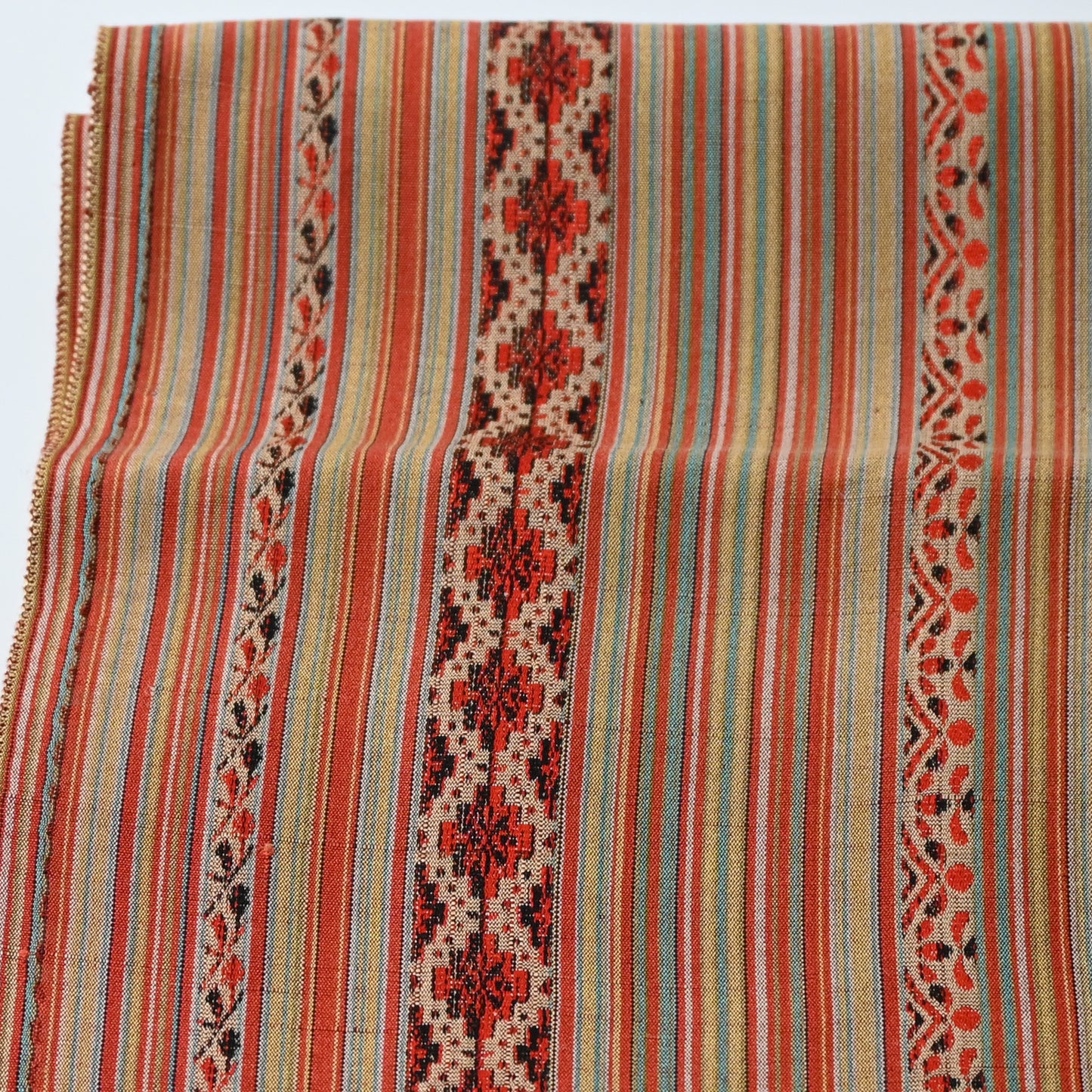Close-up view of vintage silk kimono fabric with an unusual pattern, resembling Eastern European folk textiles.