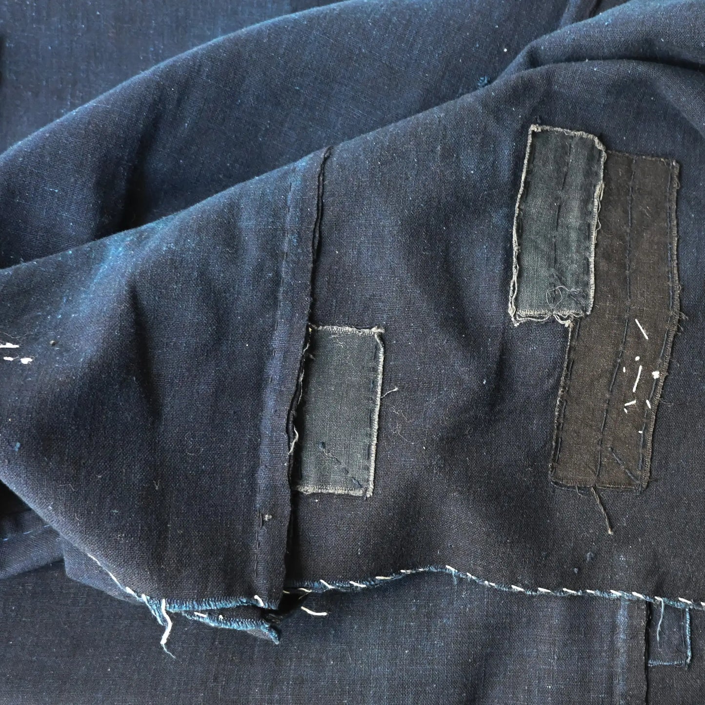 Detailed view of vintage Japanese three-panel plain indigo cotton futon cover with patches from the mid-20th century.