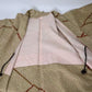 The lining of vintage women's silk shibori haori with an olive green and reddish-brown all-over pattern.