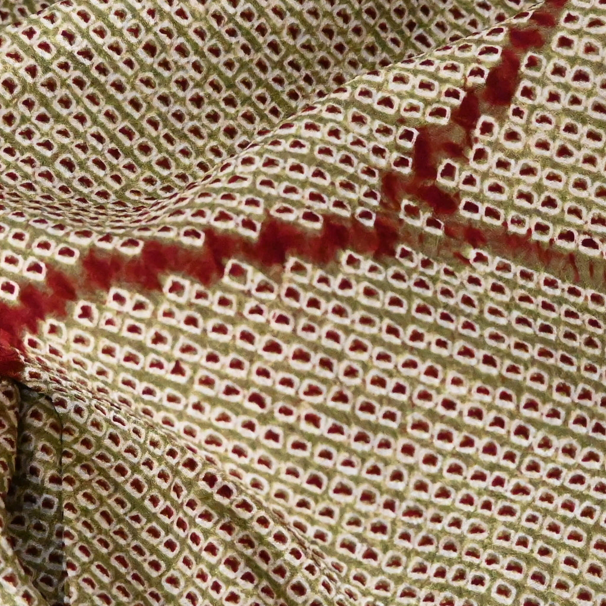 Close-up view of vintage women's silk shibori haori with an olive green and reddish-brown all-over pattern.