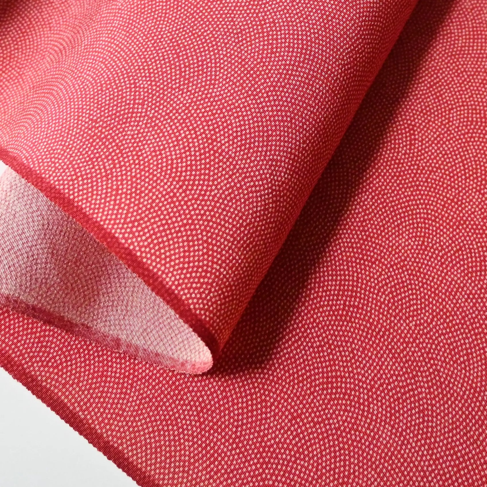 Detailed view of vintage Edokomon silk crepe kimono fabric with intricate Seigaiha dots pattern in strawberry red.