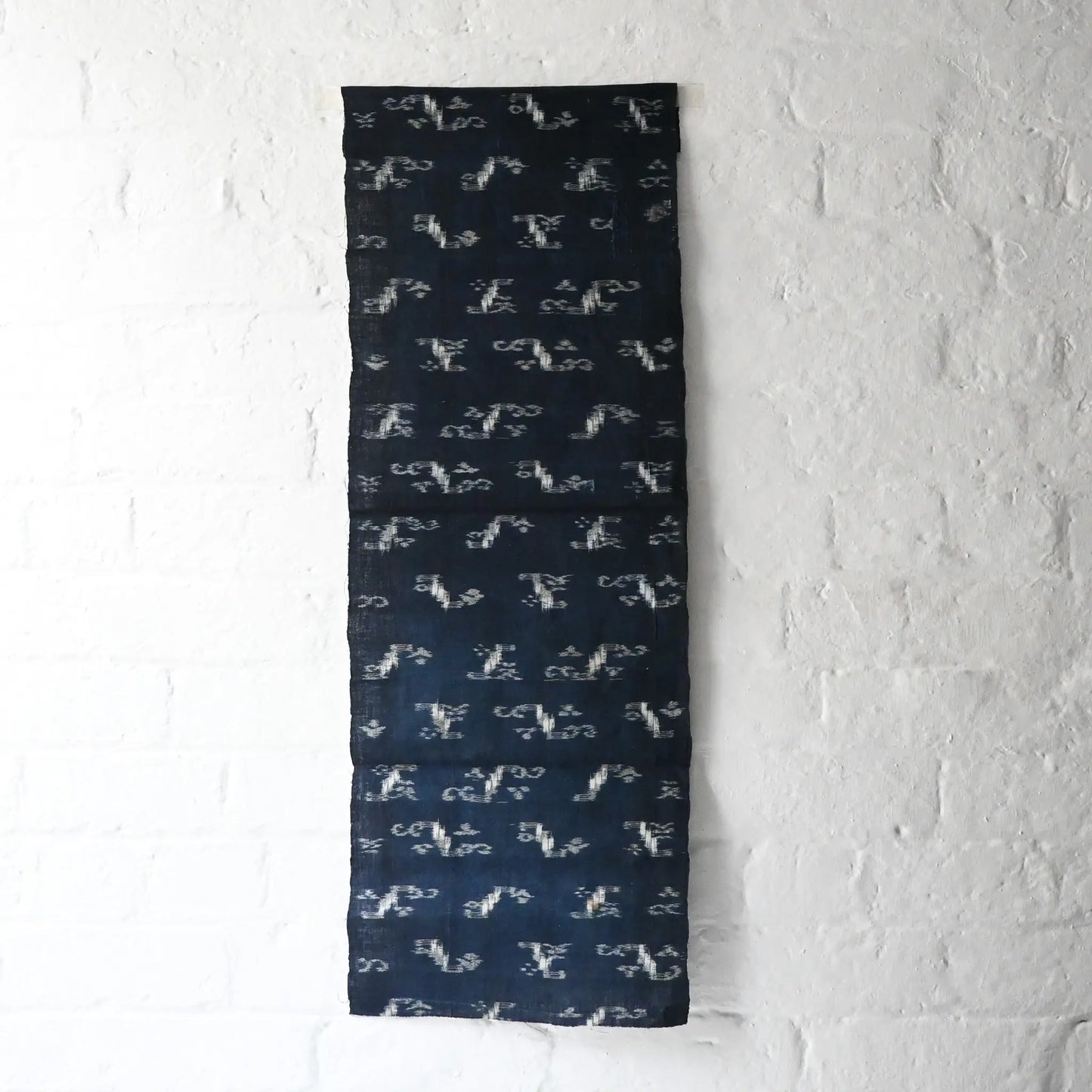 Full view of antique Japanese indigo kasuri cotton with unique motif with a mend.