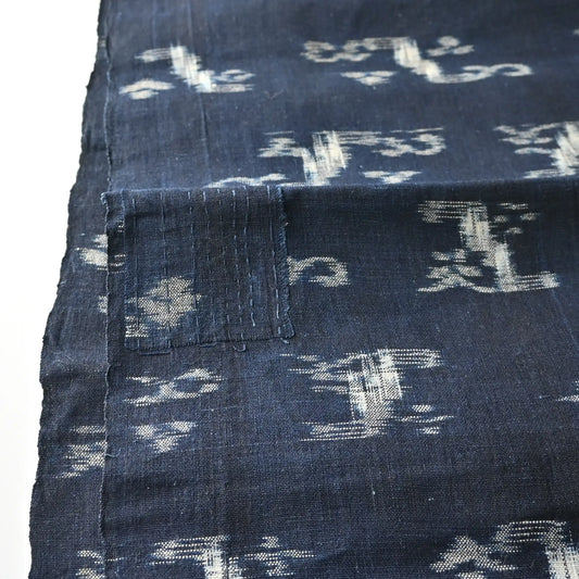 Detailed view of antique Japanese indigo kasuri cotton with unique motif with a mend.