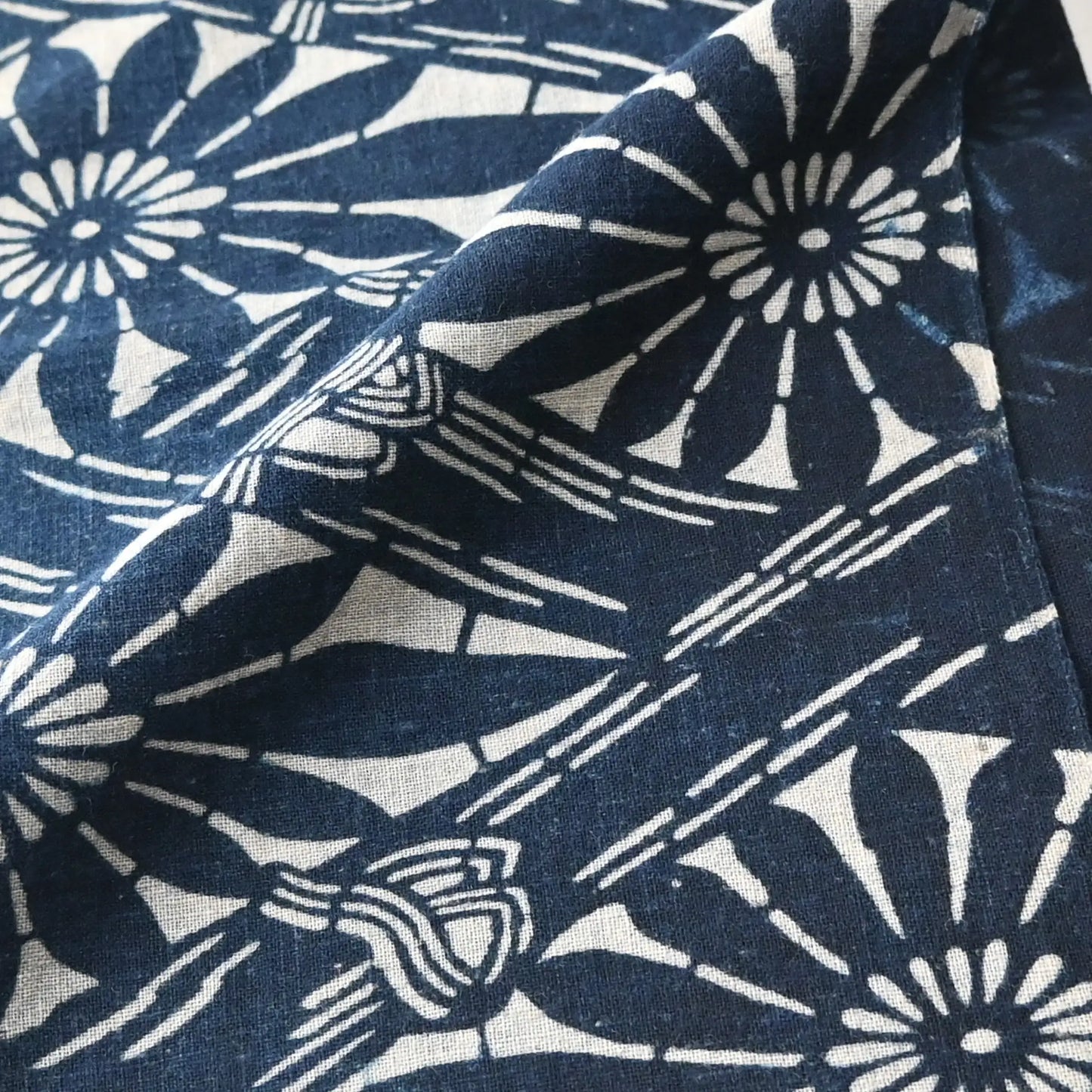 Close-up view of antique indigo katazome dyed cotton with chrysanthemum and bamboo motifs from early 20th century.