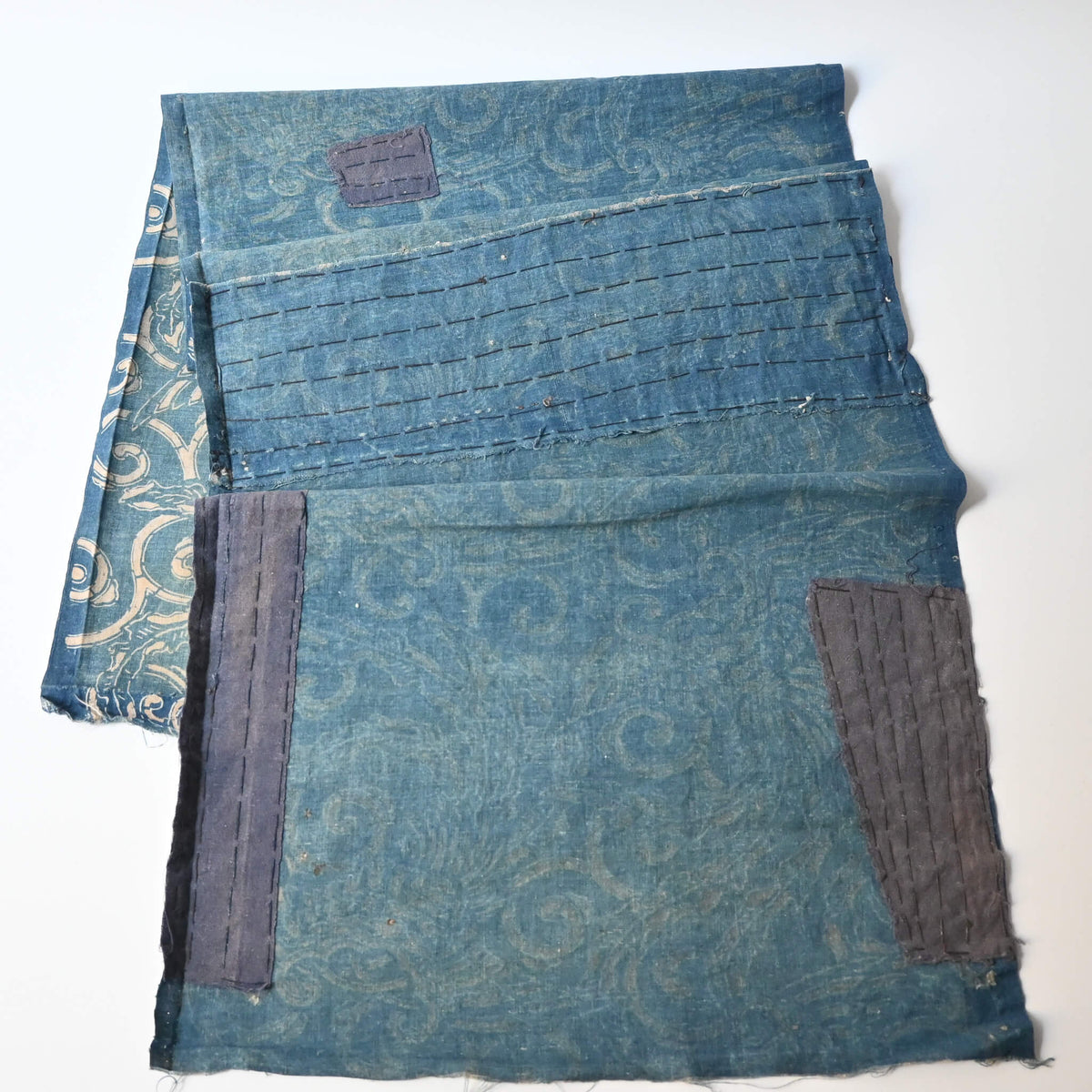 Back of antique indigo katazome cotton with phoenix pattern with mended patches.