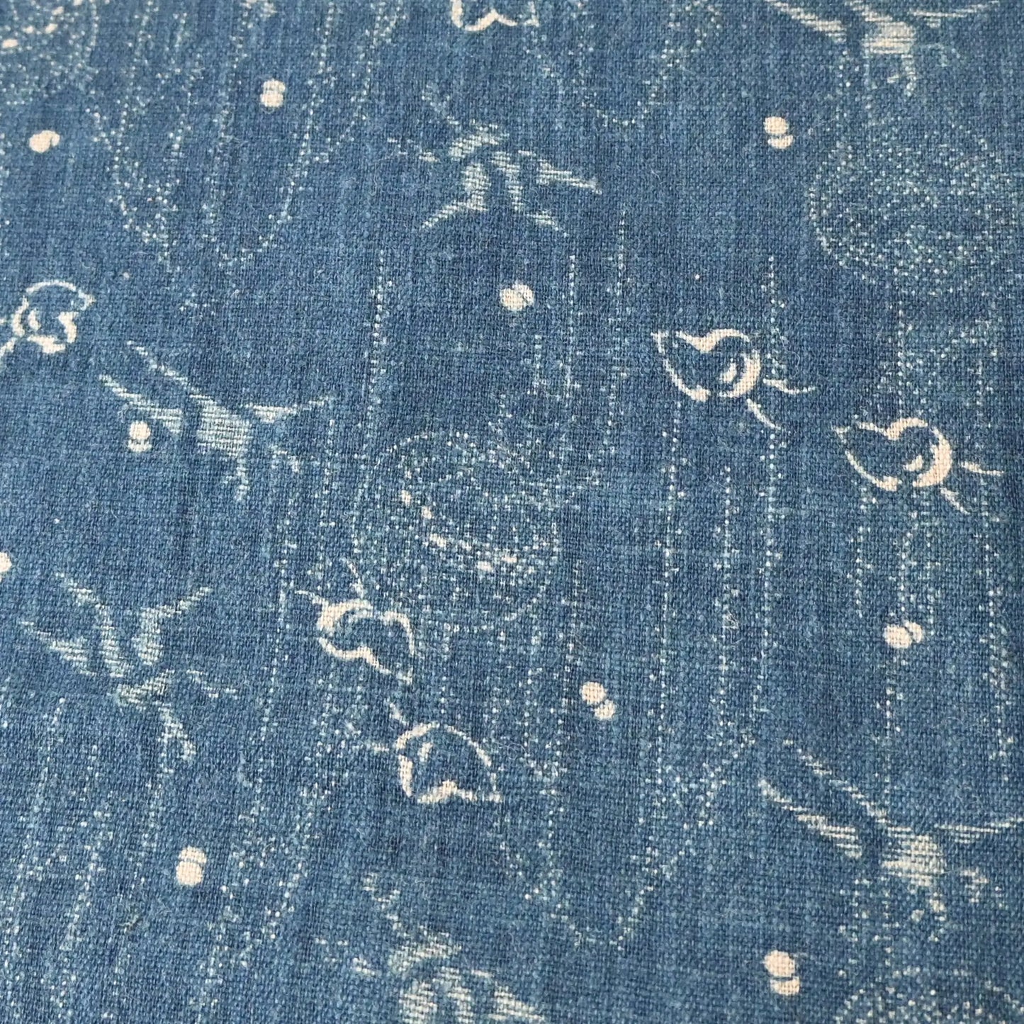 Close-up view of fragment of antique indigo katazome cotton with small patters of plover, willow, tamari ball and crane, late 19th century to early 20th century.