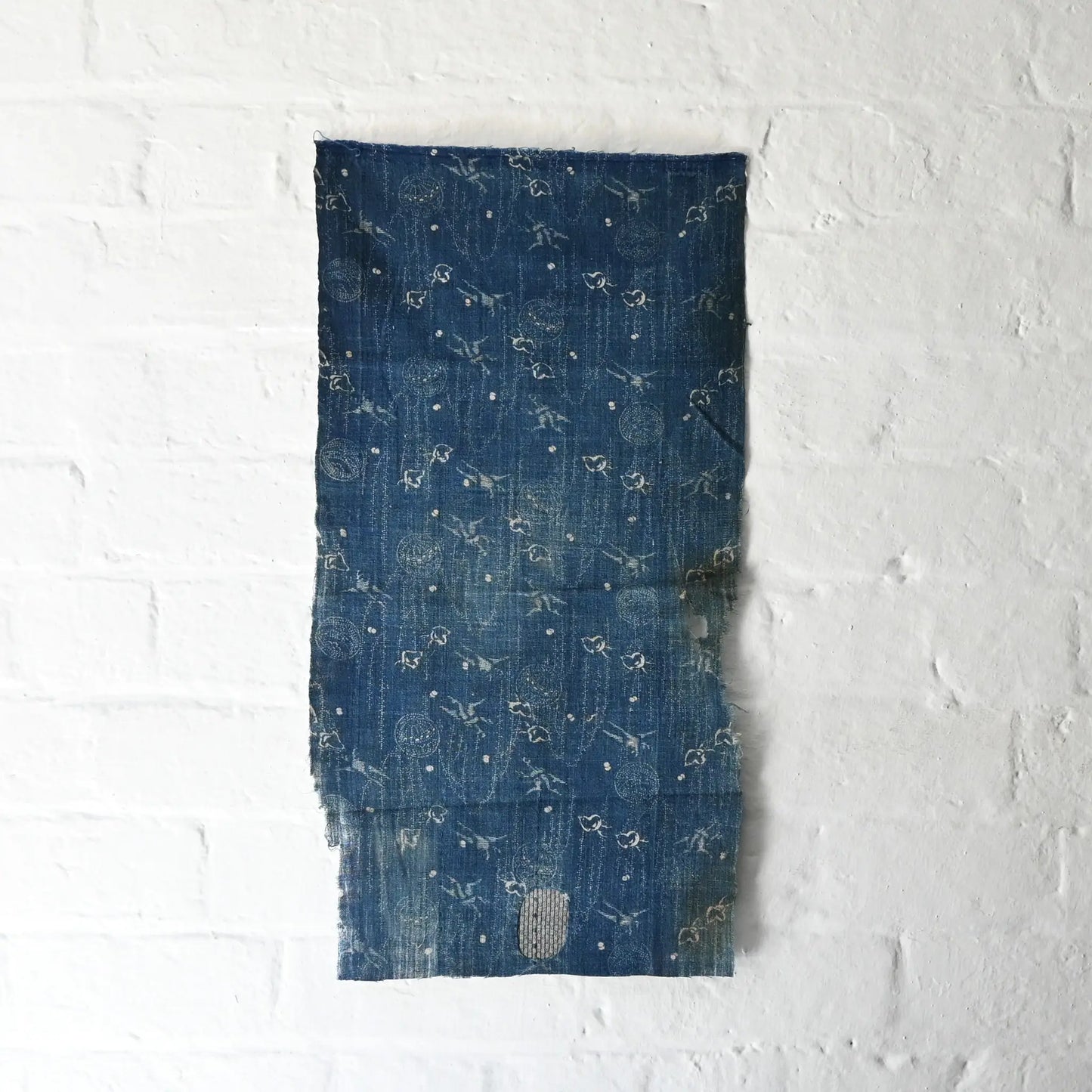 Full view of fragment of antique indigo katazome cotton with small patters of plover, willow, tamari ball and crane, late 19th century to early 20th century.