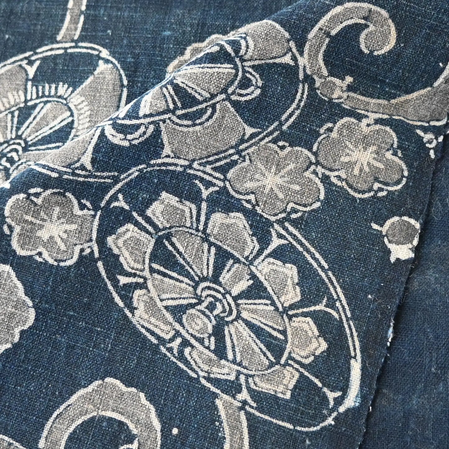 Close-up view of antique indigo katazome cotton with wagasa and plum blossom motifs, from early 20th century.