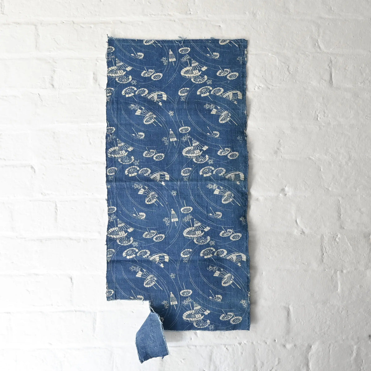 Hanging view of antique indigo katazome cotton with flowing wagasa (Japanese paper umbrellas) and cherry blossom motifs.