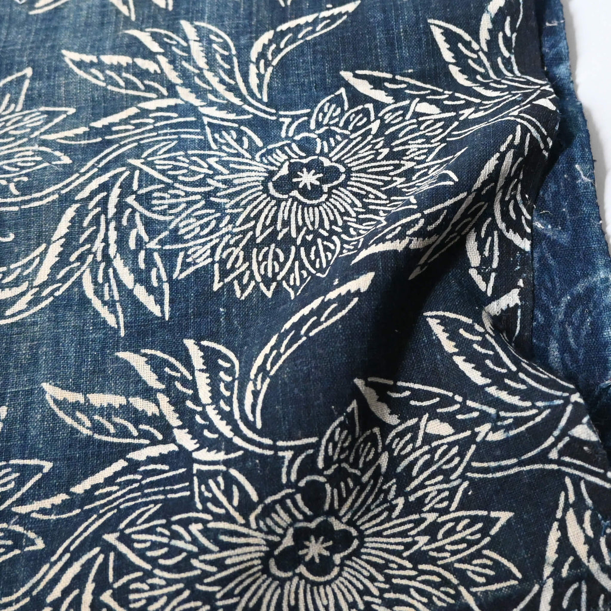 Detailed view of antique indigo katazome dyed cotton futon cover panel with chrysanthemum pattern.