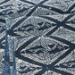 Cloe-up view of antique Japanese indigo katazome dyed cotton with a repeating pattern of paired cranes within diamond-shaped motifs.
