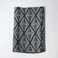 Antique Japanese indigo katazome dyed cotton with a repeating pattern of paired cranes within diamond-shaped motifs.