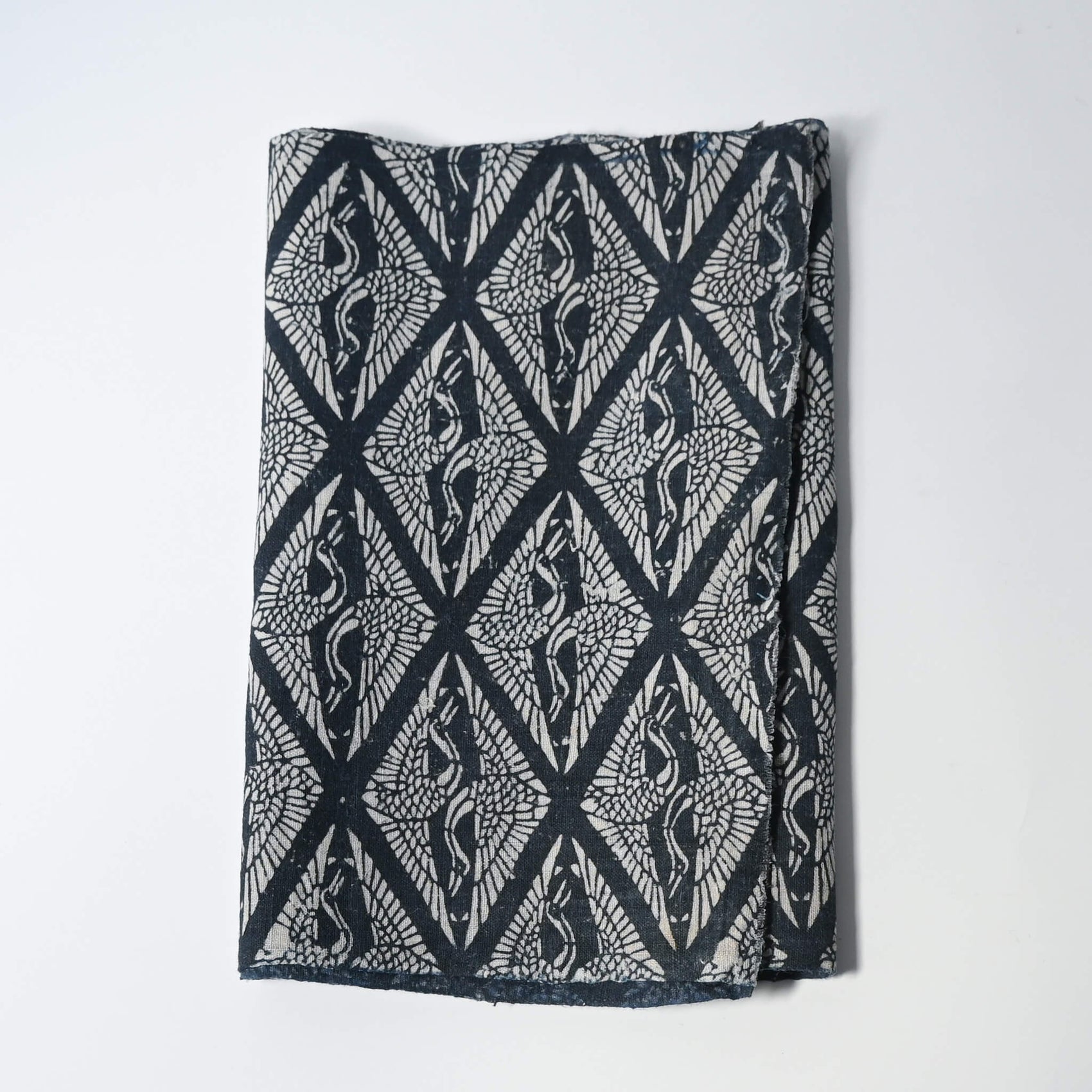 Antique Japanese indigo katazome dyed cotton with a repeating pattern of paired cranes within diamond-shaped motifs.