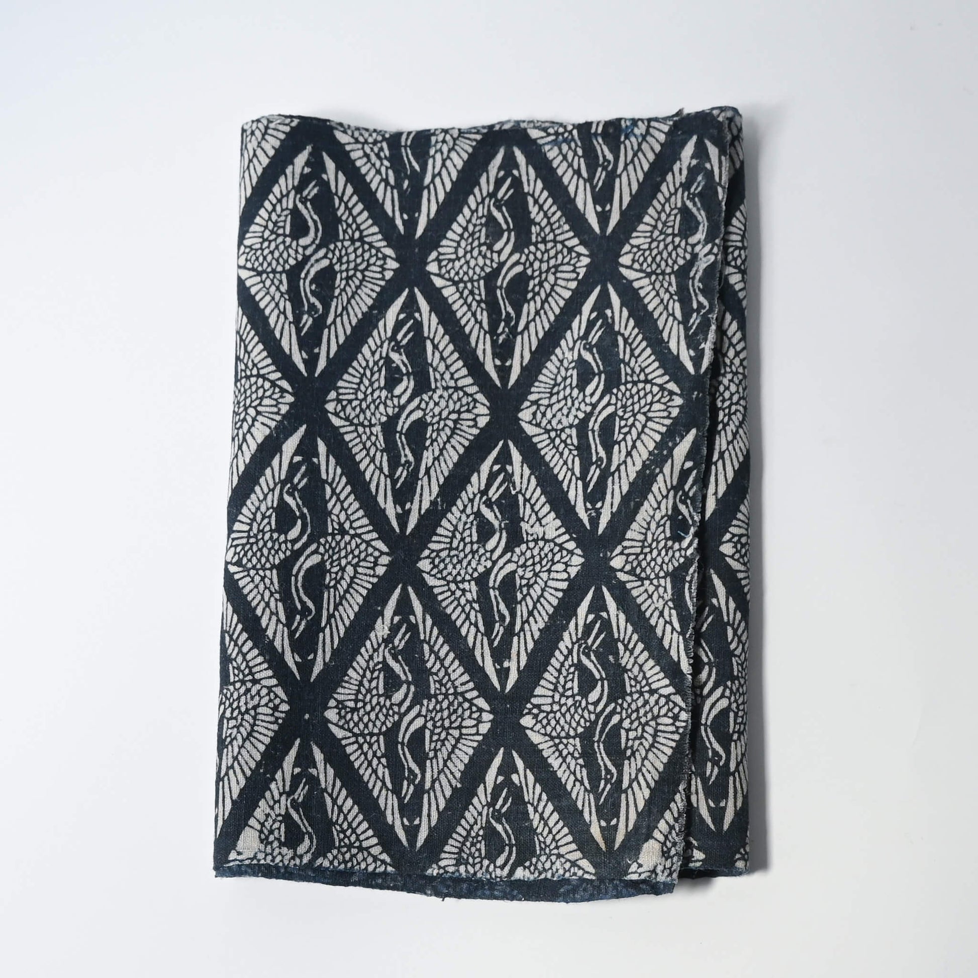 Antique Japanese indigo katazome dyed cotton with a repeating pattern of paired cranes within diamond-shaped motifs.