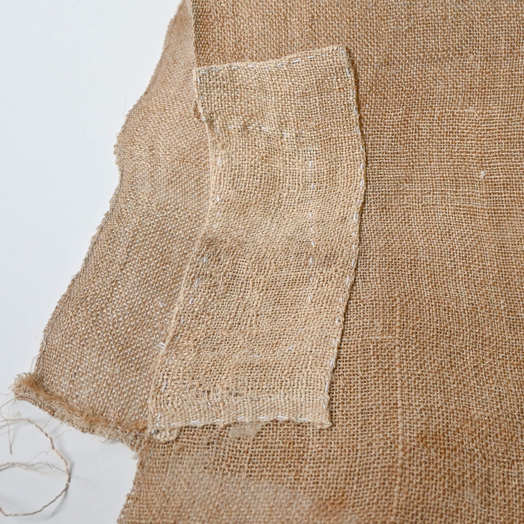 Detailed view of antique Japanese natural thick hemp with a patch, rustic feel.