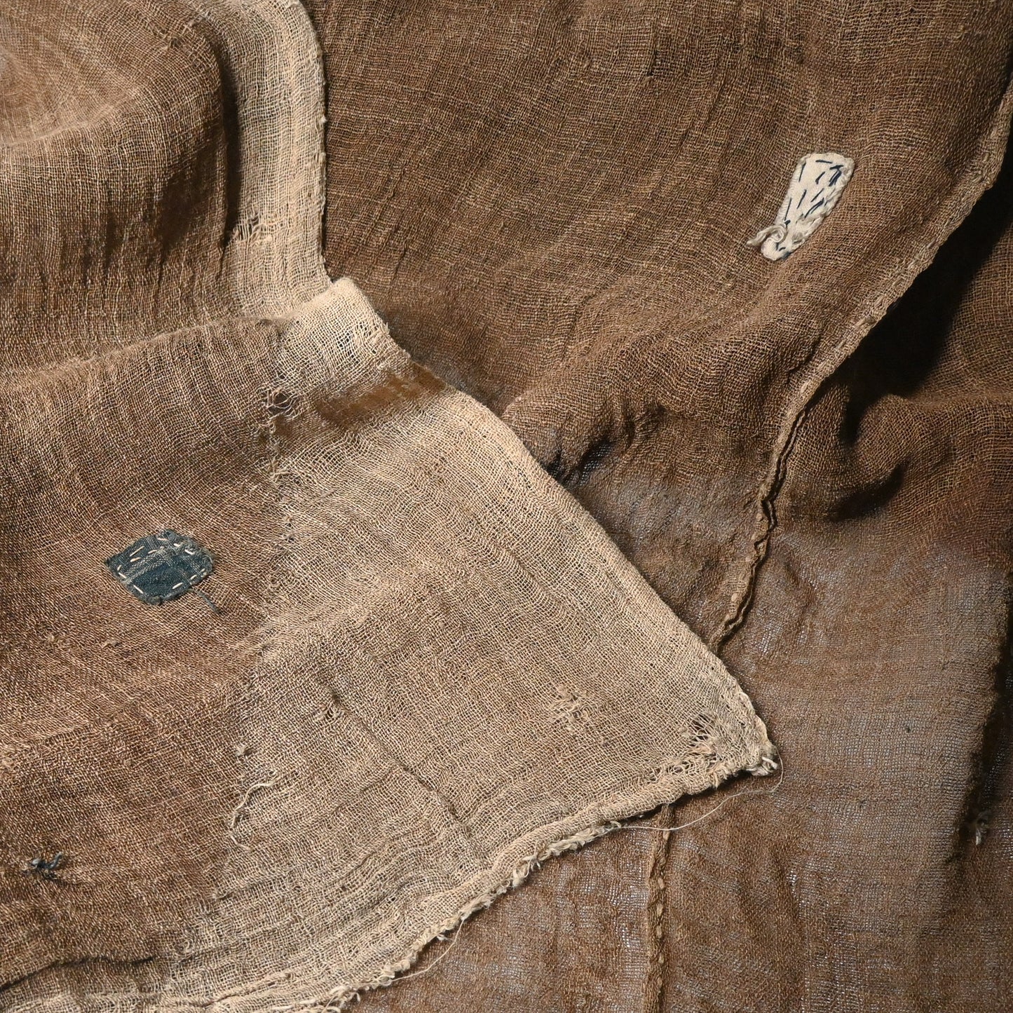Detailed view of antique Japanese natural brown six-panel hemp mosquito net Kaya with beautiful mends.
