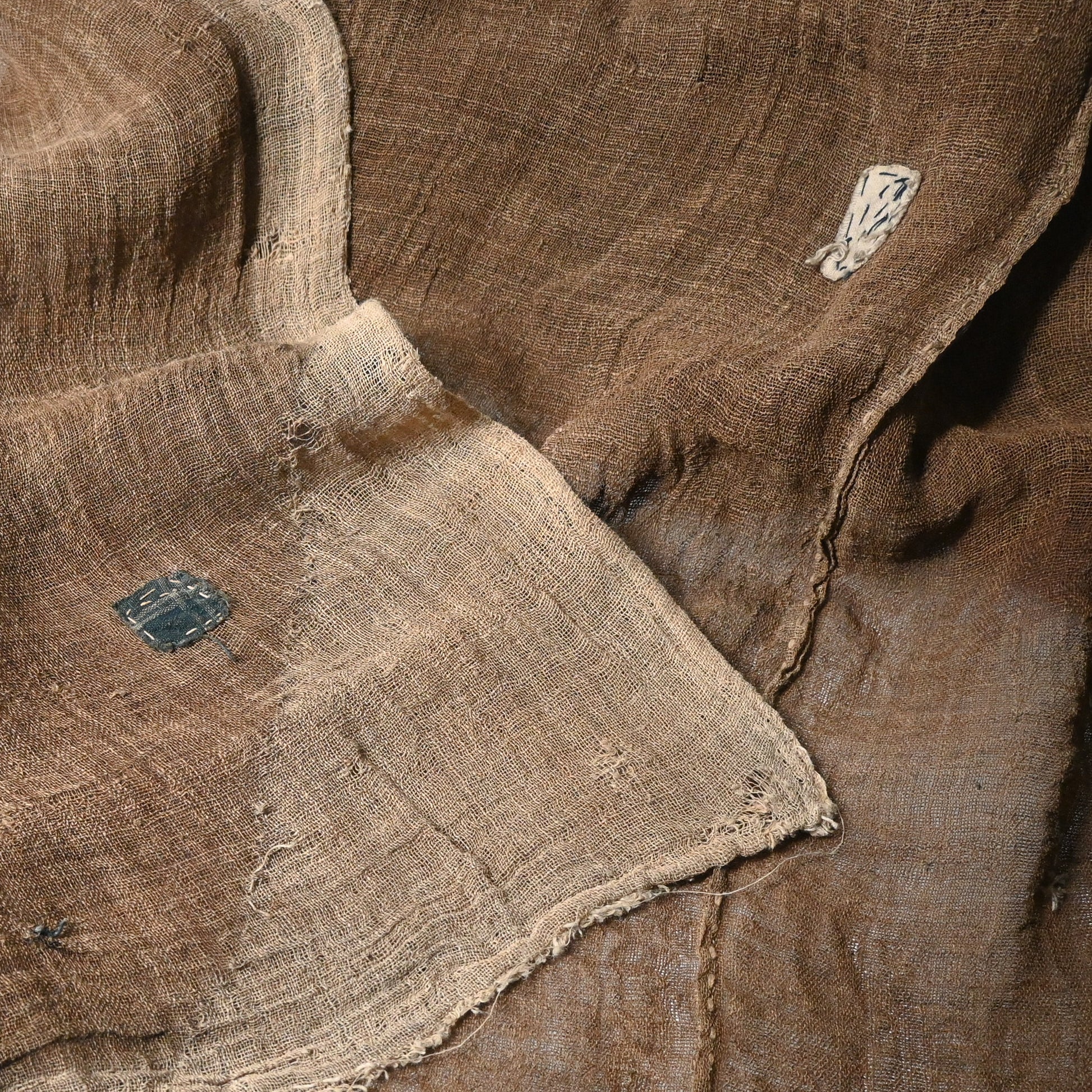 Detailed view of antique Japanese natural brown six-panel hemp mosquito net Kaya with beautiful mends.