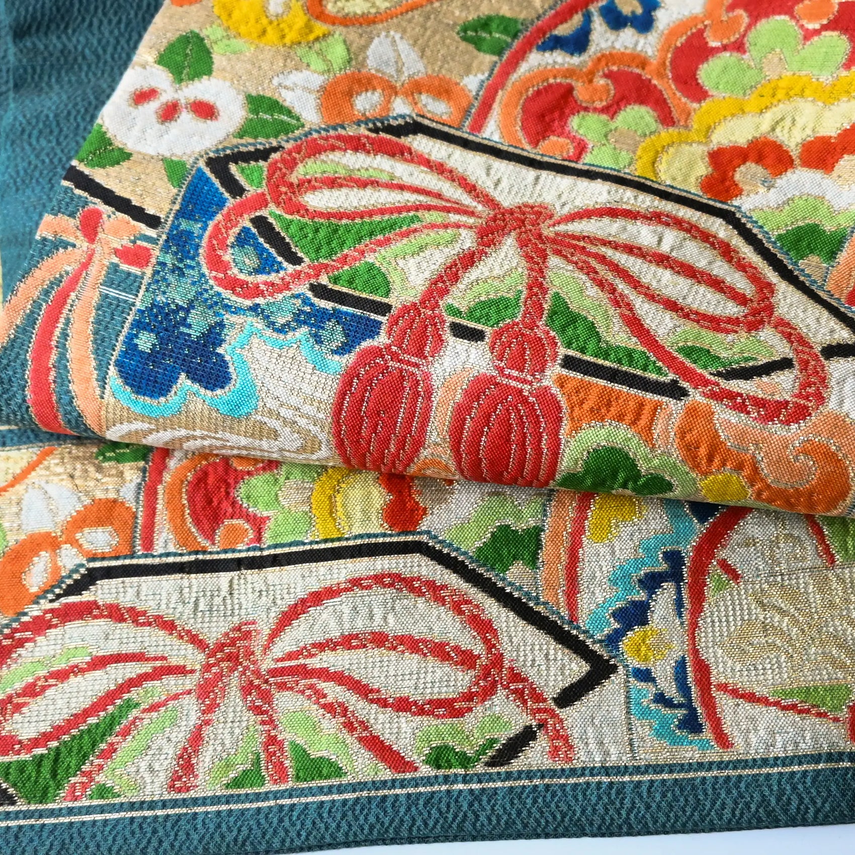 Detailed view of antique Japanese women's teal blue Nagoya obi with gorgeous fan and Kaioke motif from 1930-40s.