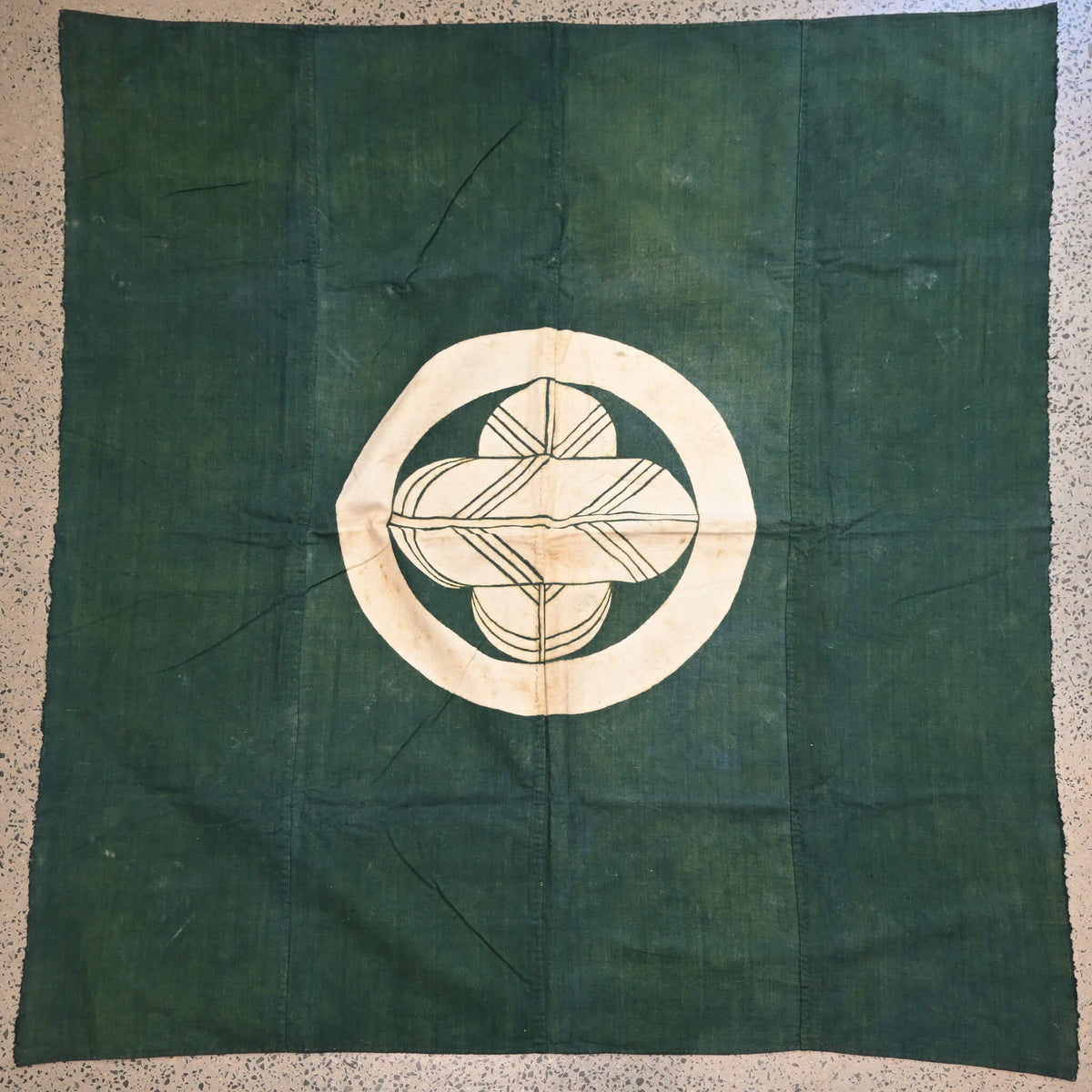 Full view of antique indigo green cotton furoshiki with family crest mon from the early 20th century.