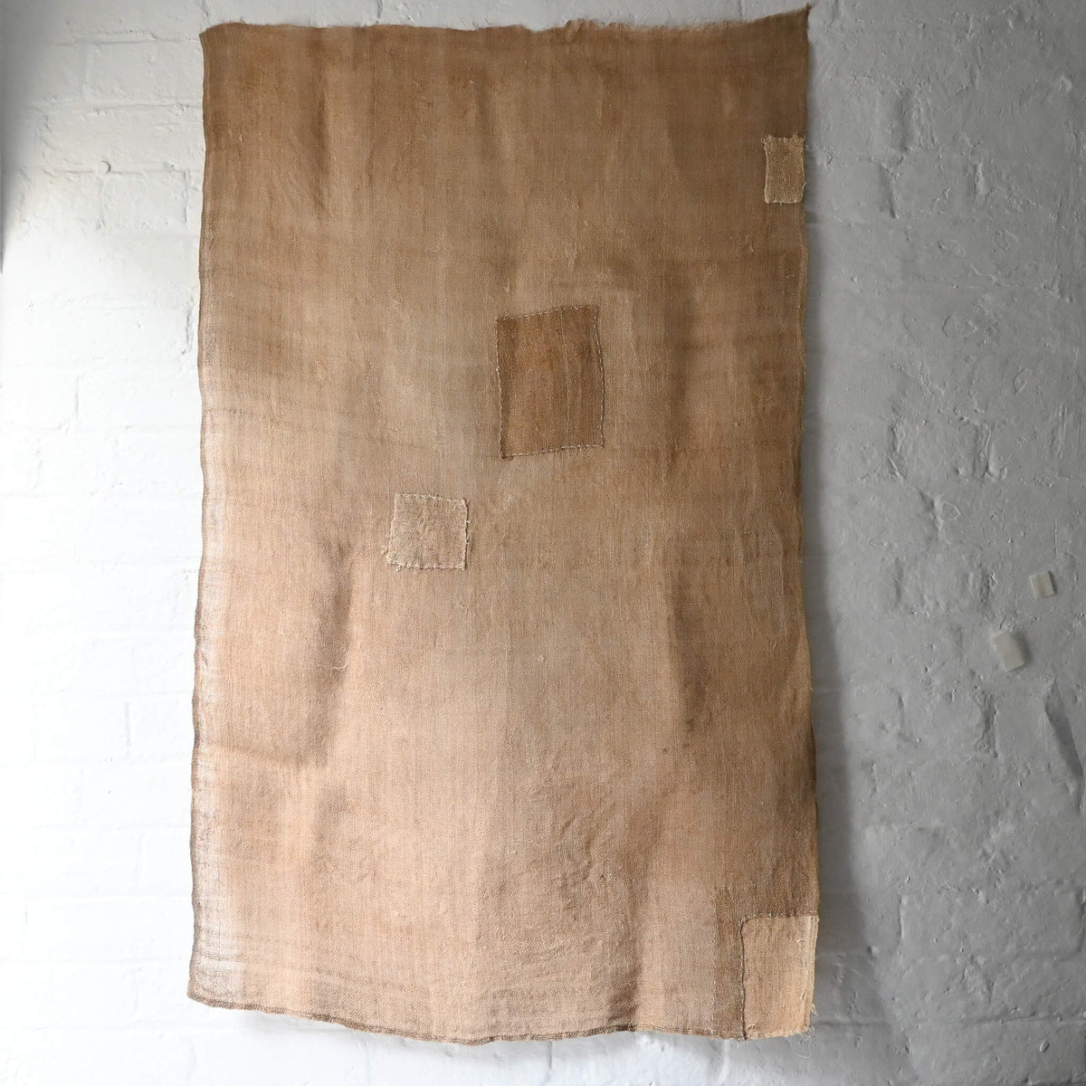 Full view of antique natural wide width hemp cloth with mends with rustic feel.