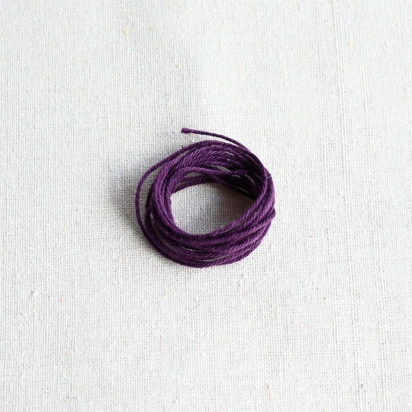 Authentic Japanese Hida sashiko threads in aubergine on calico cotton.