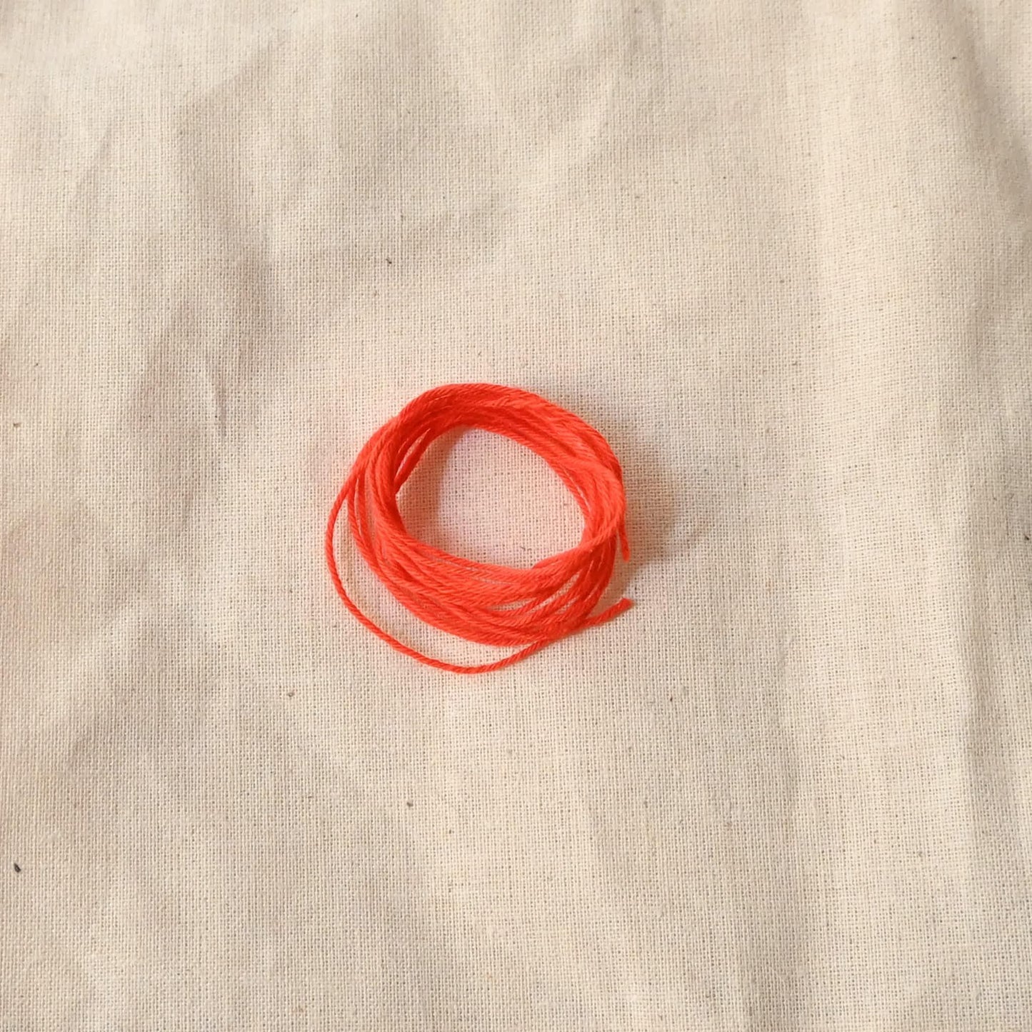 Authentic Japanese Hida sashiko threads in bright orange on calico cotton.