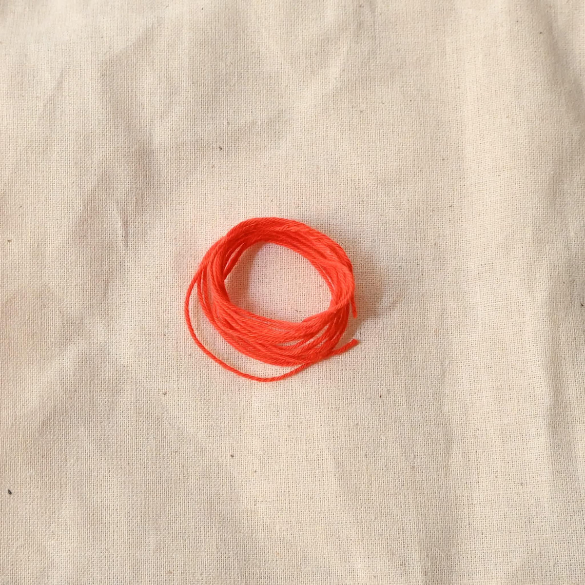 Authentic Japanese Hida sashiko threads in bright orange on calico cotton.